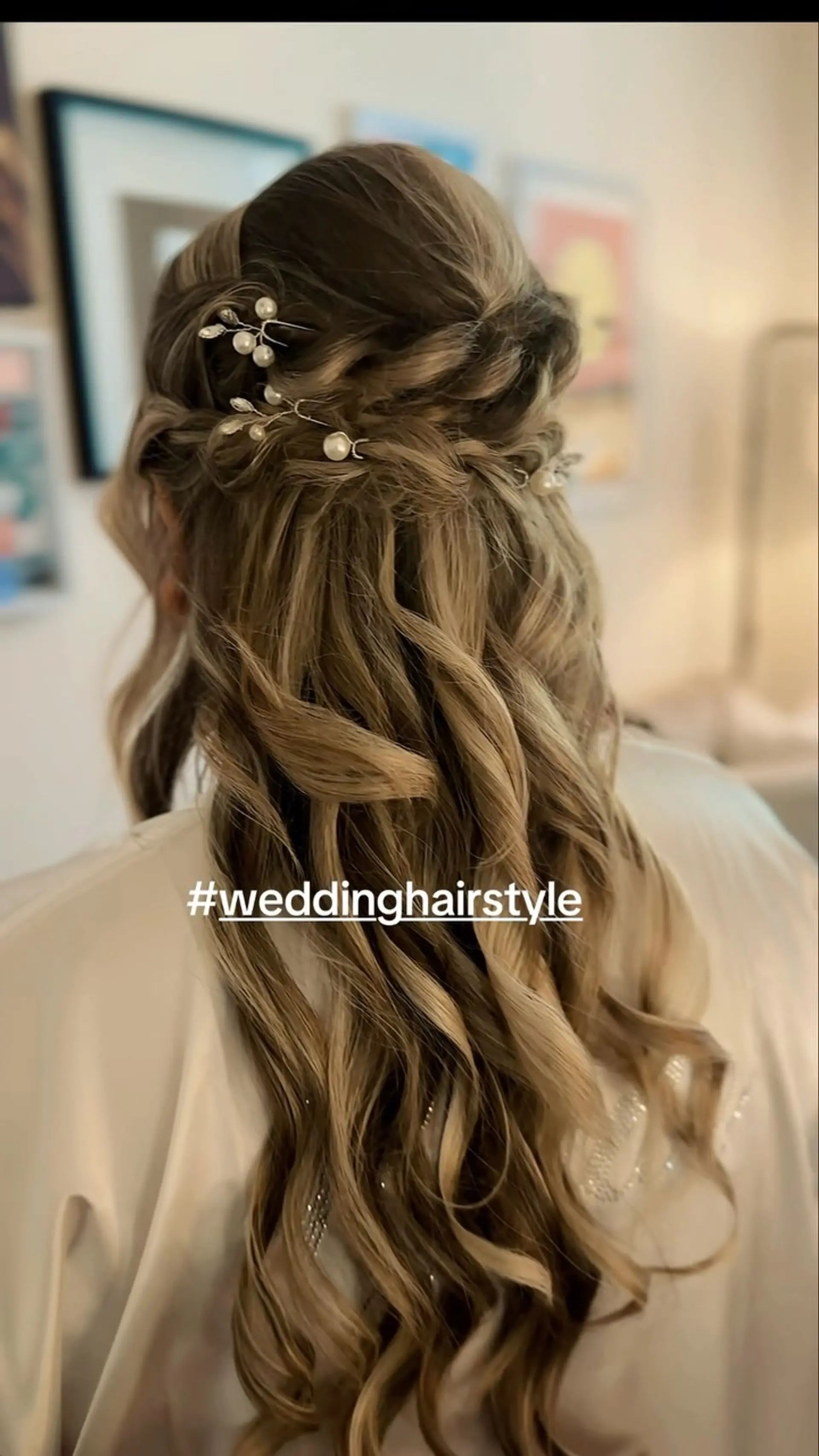 Romantic bridal half-up half-down hairstyle adorned with delicate pearl accessories and flowing loose curls. 1
