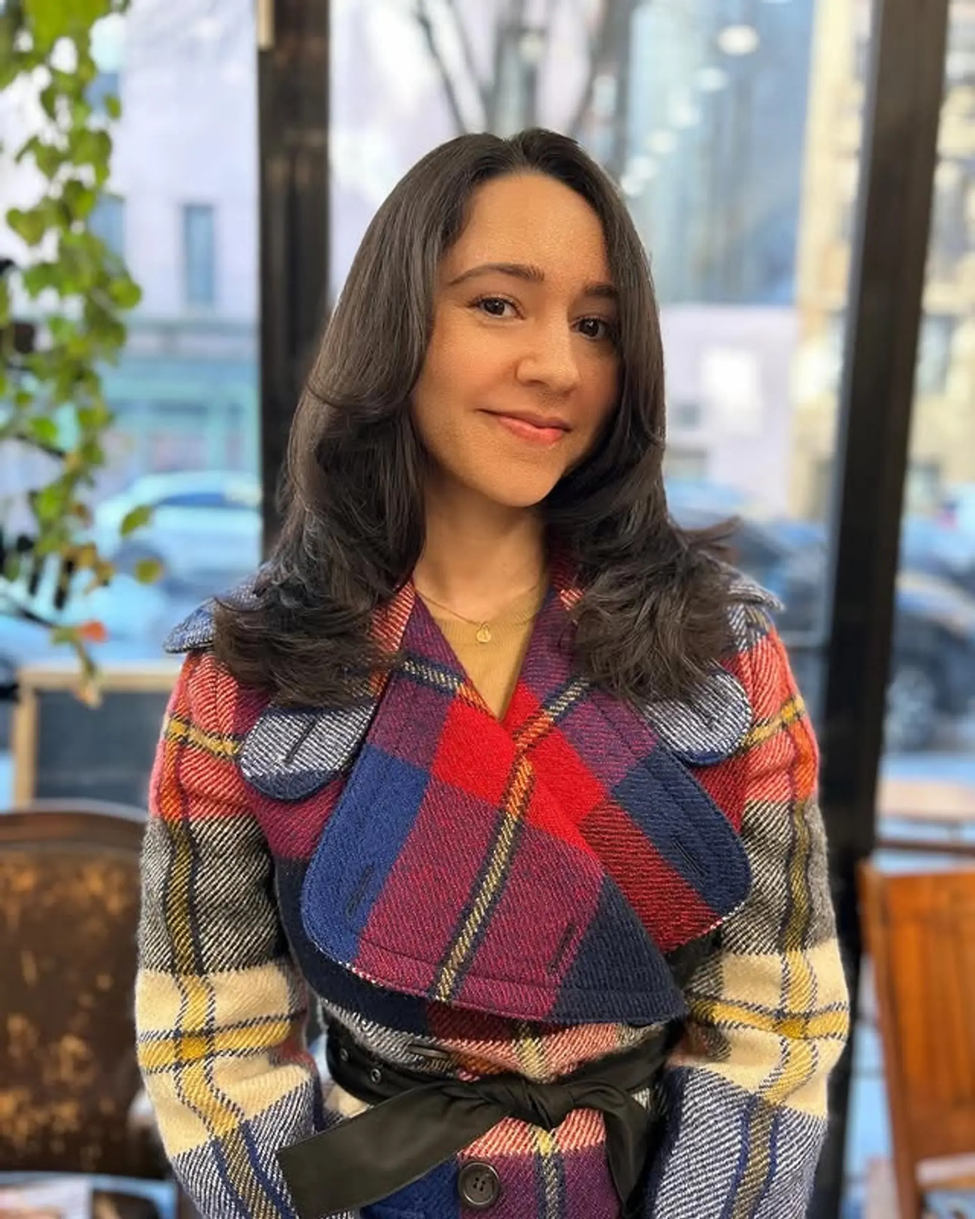 A medium-length layered hairstyle with curtain bangs and soft waves. 1