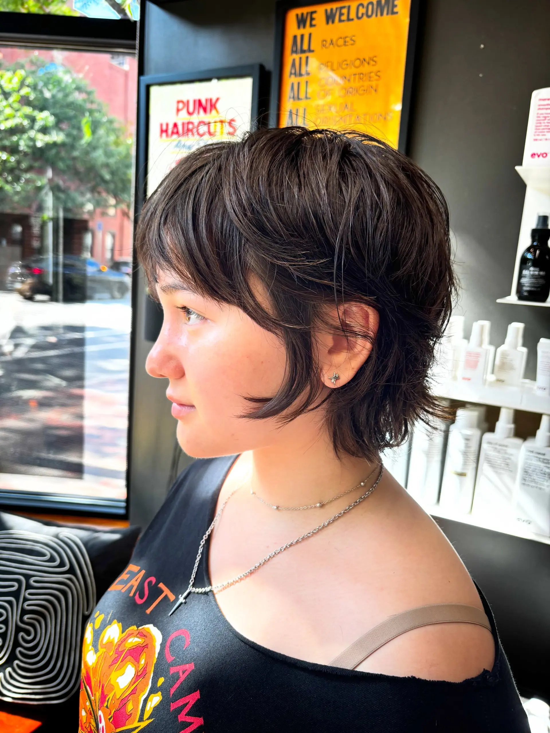 A layered bixie cut featuring soft, wispy bangs, feathered crown layers, and razored, face-framing tendrils. 1