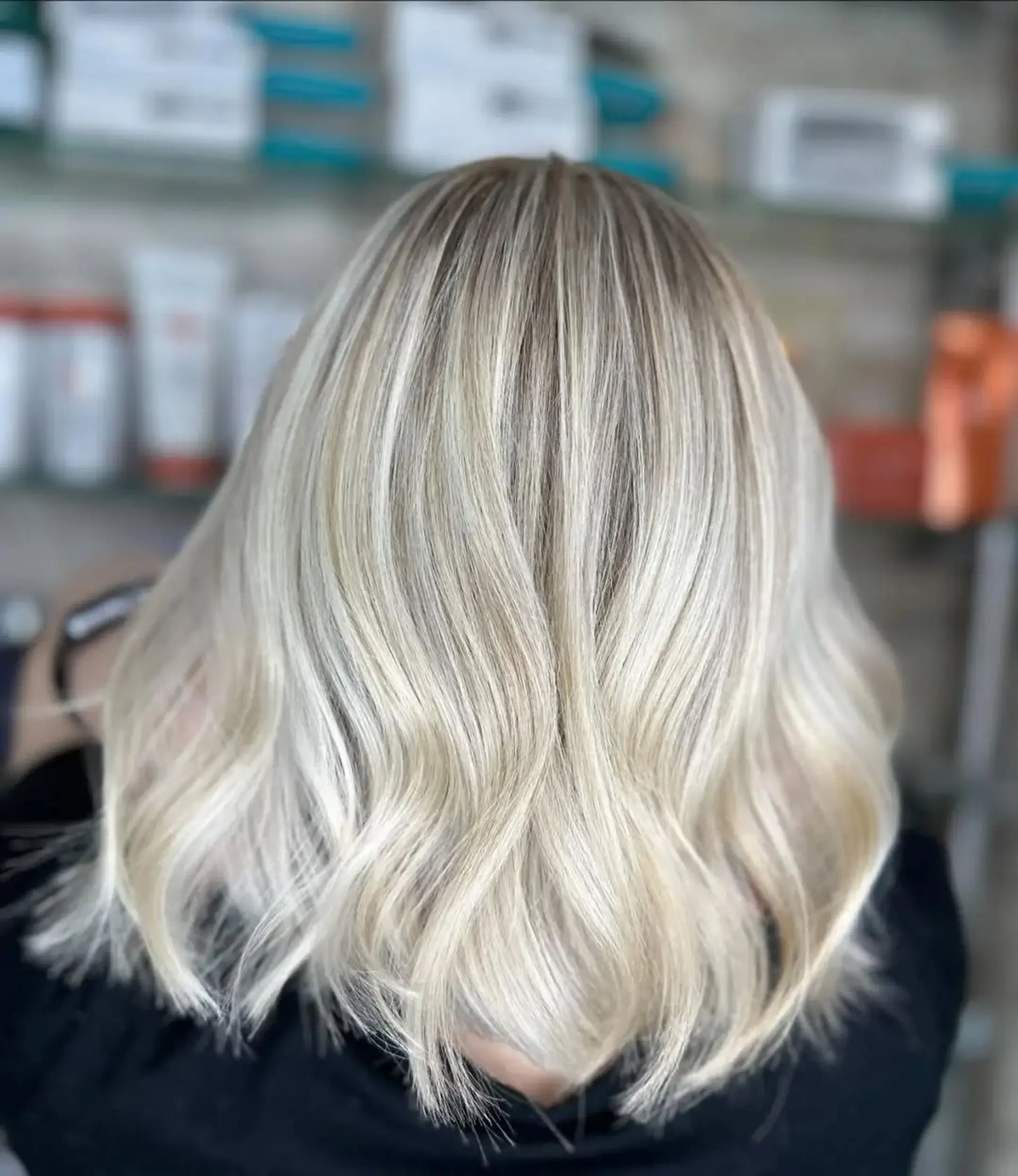 This is a medium-length lob with a wavy finish and a balayage blonde coloring. 1