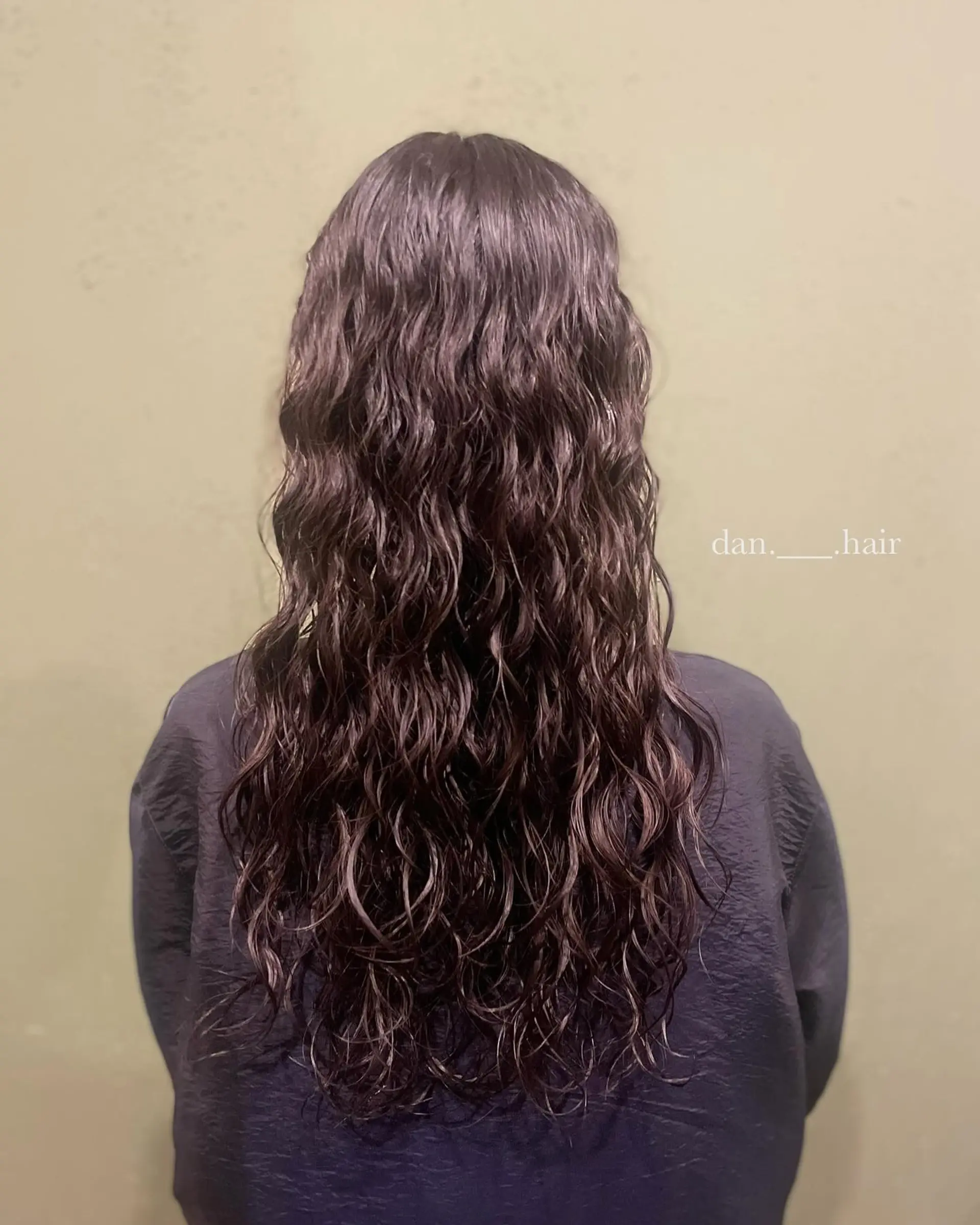 Long dark hair styled with an all-over hippie perm featuring defined, uniform ripple waves. 1