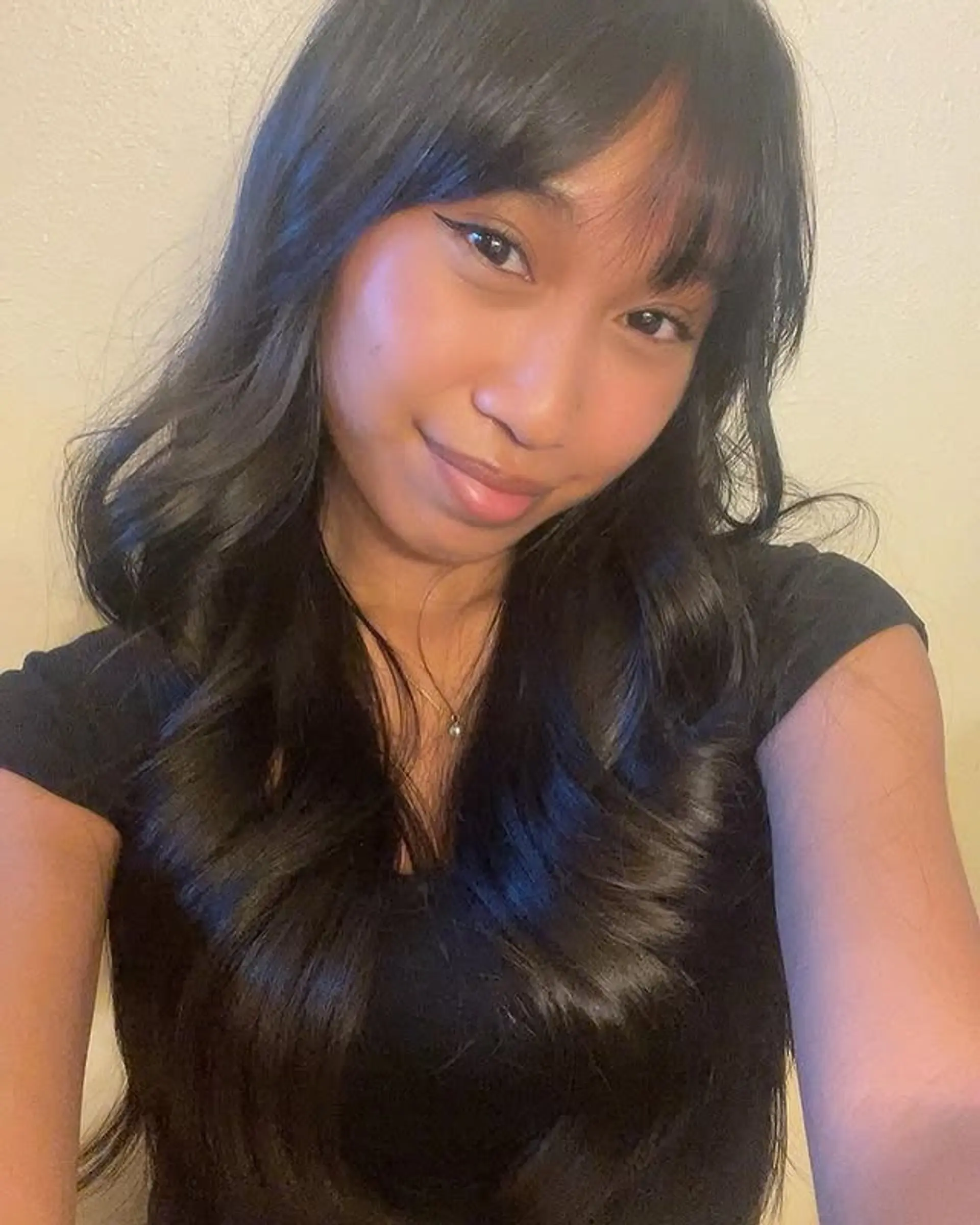 Long layered hairstyle with soft waves and curtain bangs. 1