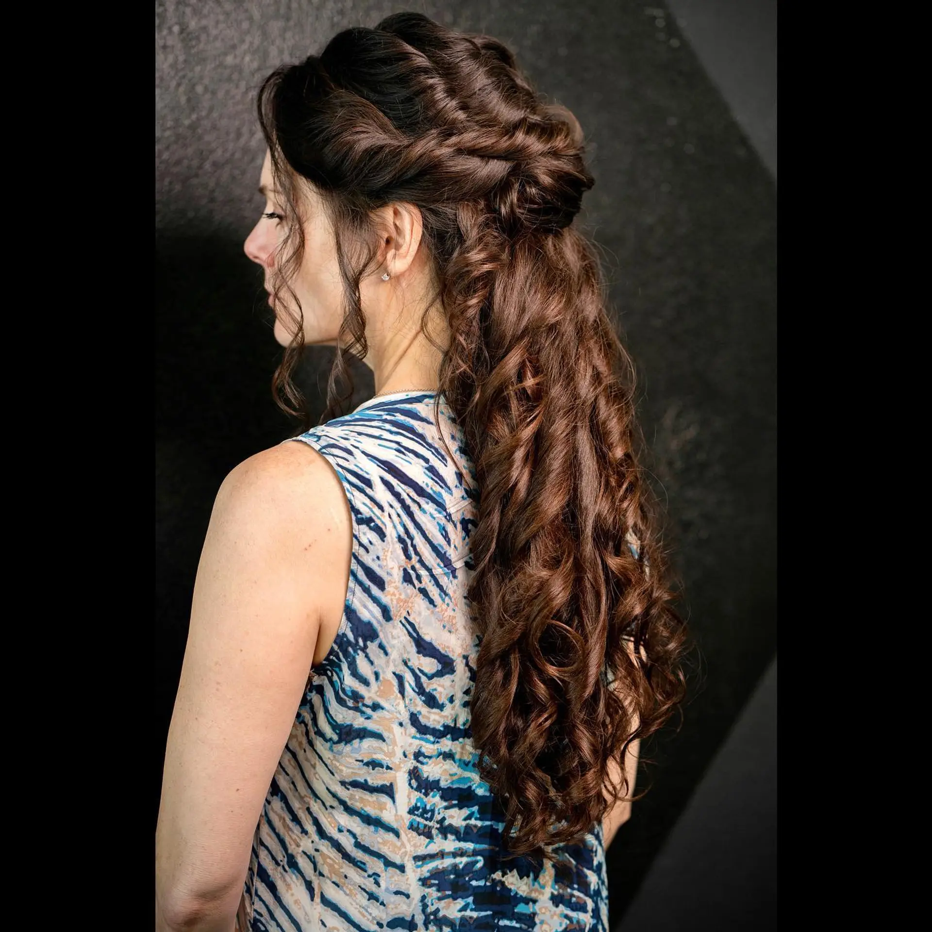 Romantic half updo with intricate braiding and cascading curls. 1