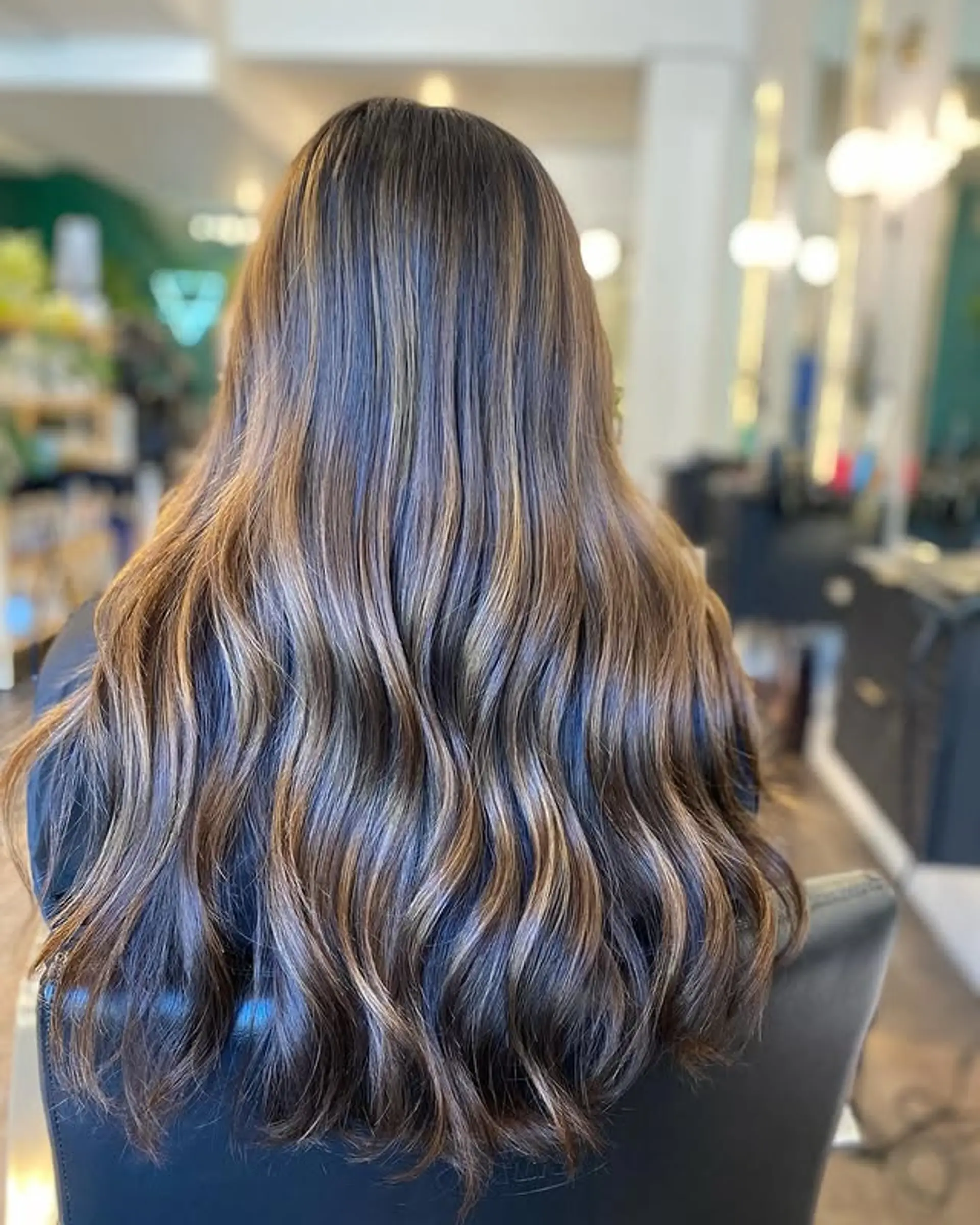 Long, wavy hair with a balayage effect, creating a bronzed and dimensional look. 1