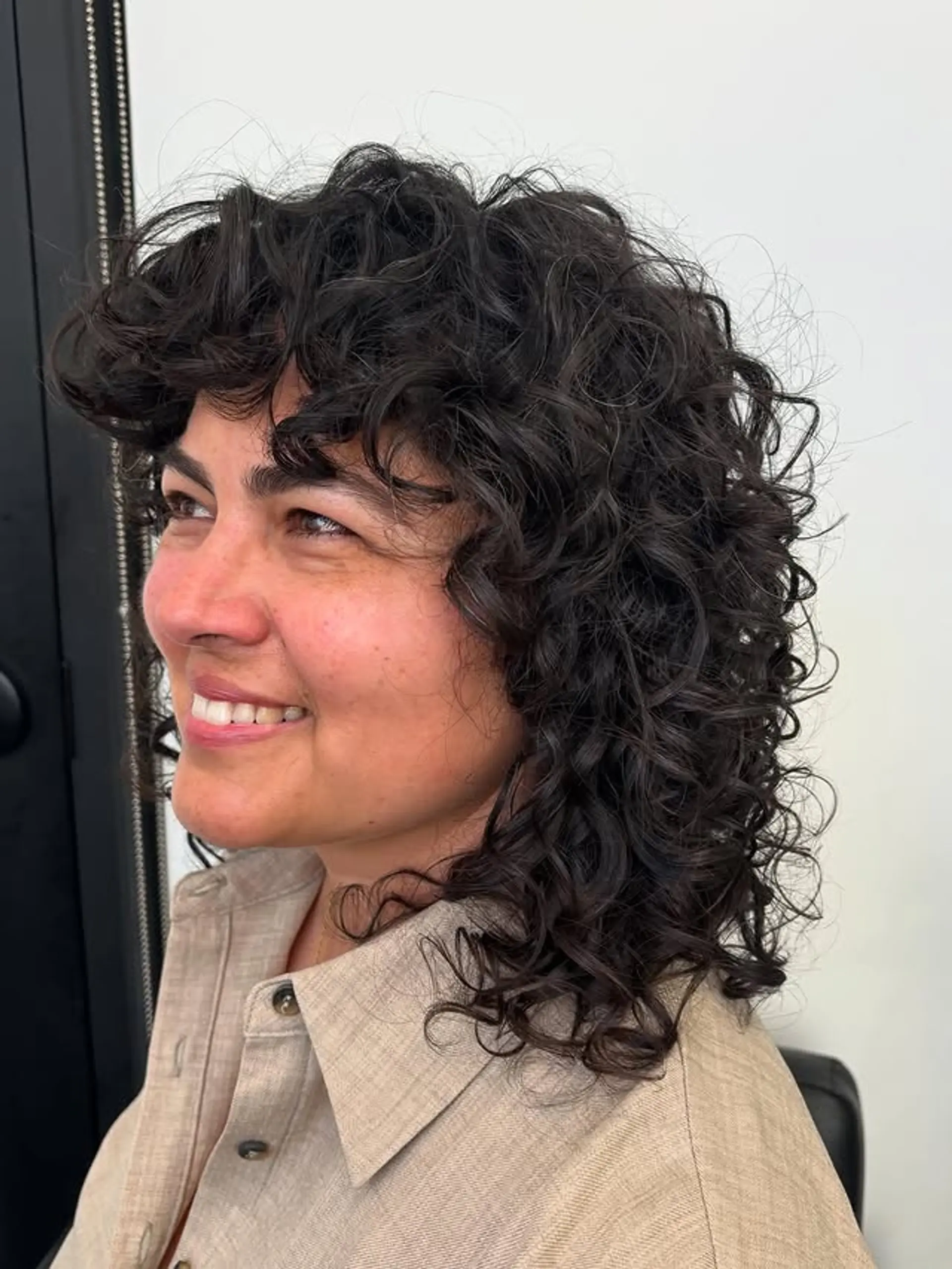 A stylish and modern curly shag haircut with fringe bangs and lots of layers. 1