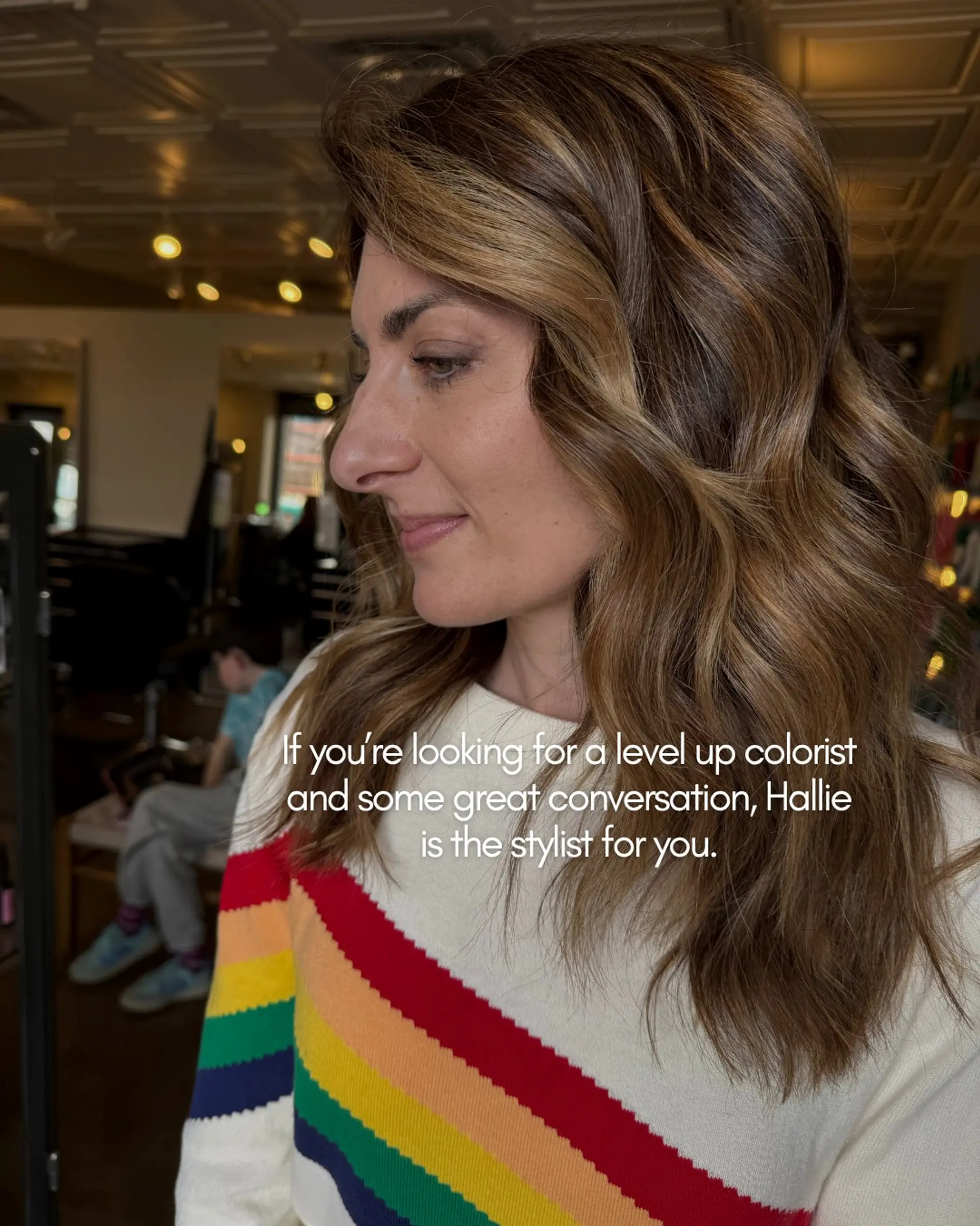 Rich medium brown hair highlighted with warm caramel balayage tones and styled in soft, cascading waves. 1