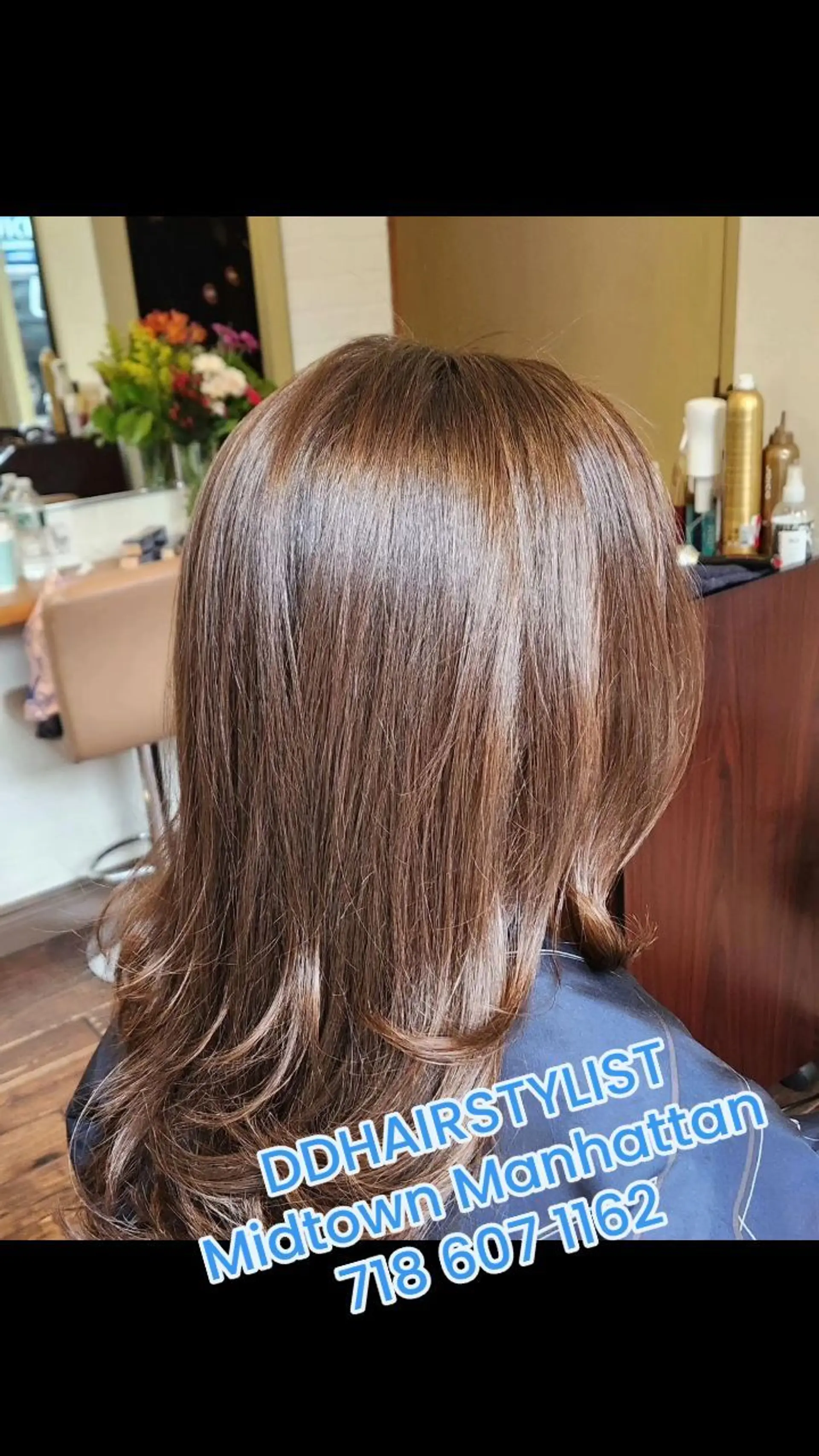 Medium-length glossy light chestnut brown hair styled with a sleek blowout and subtle soft flips at the ends. 1