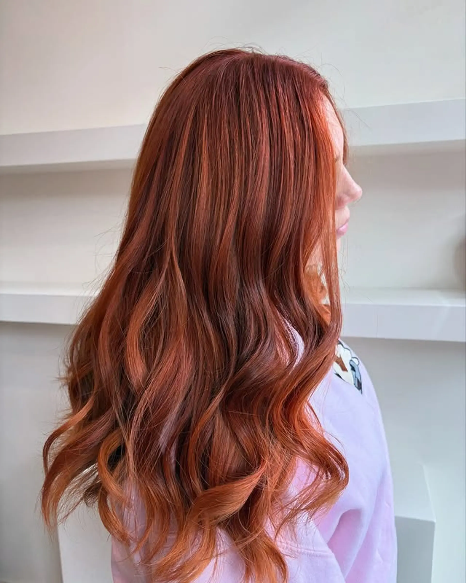 A long wavy hairstyle with a copper penny balayage. 1