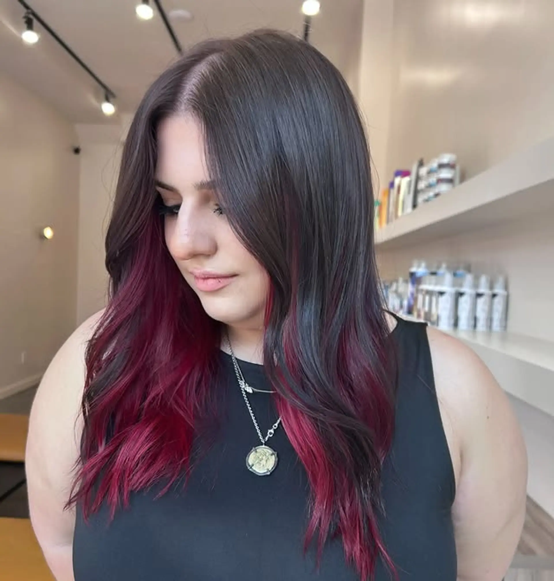 Medium length wavy hair with soft layers and a burgundy money piece. 1