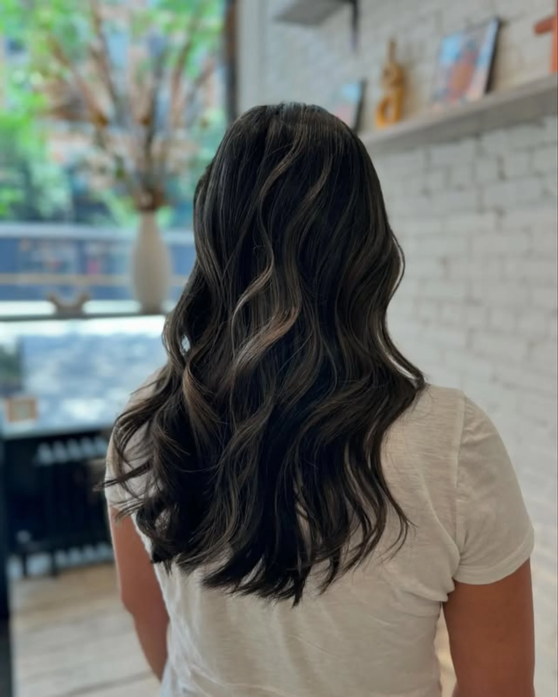 Long wavy hair styled with bold caramel ribbon highlights layered over a dark brunette base - Preview 3