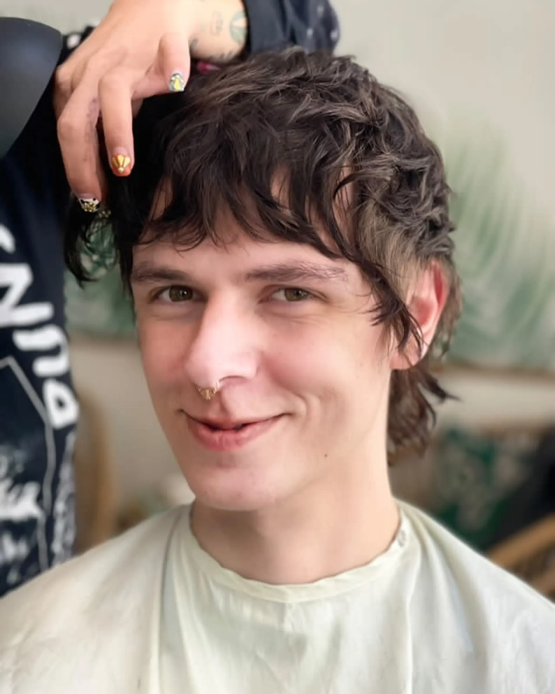 A medium-length, dark brown hairstyle with shaggy layers, choppy ends, and a casual tousled texture with a slight fringe. 1