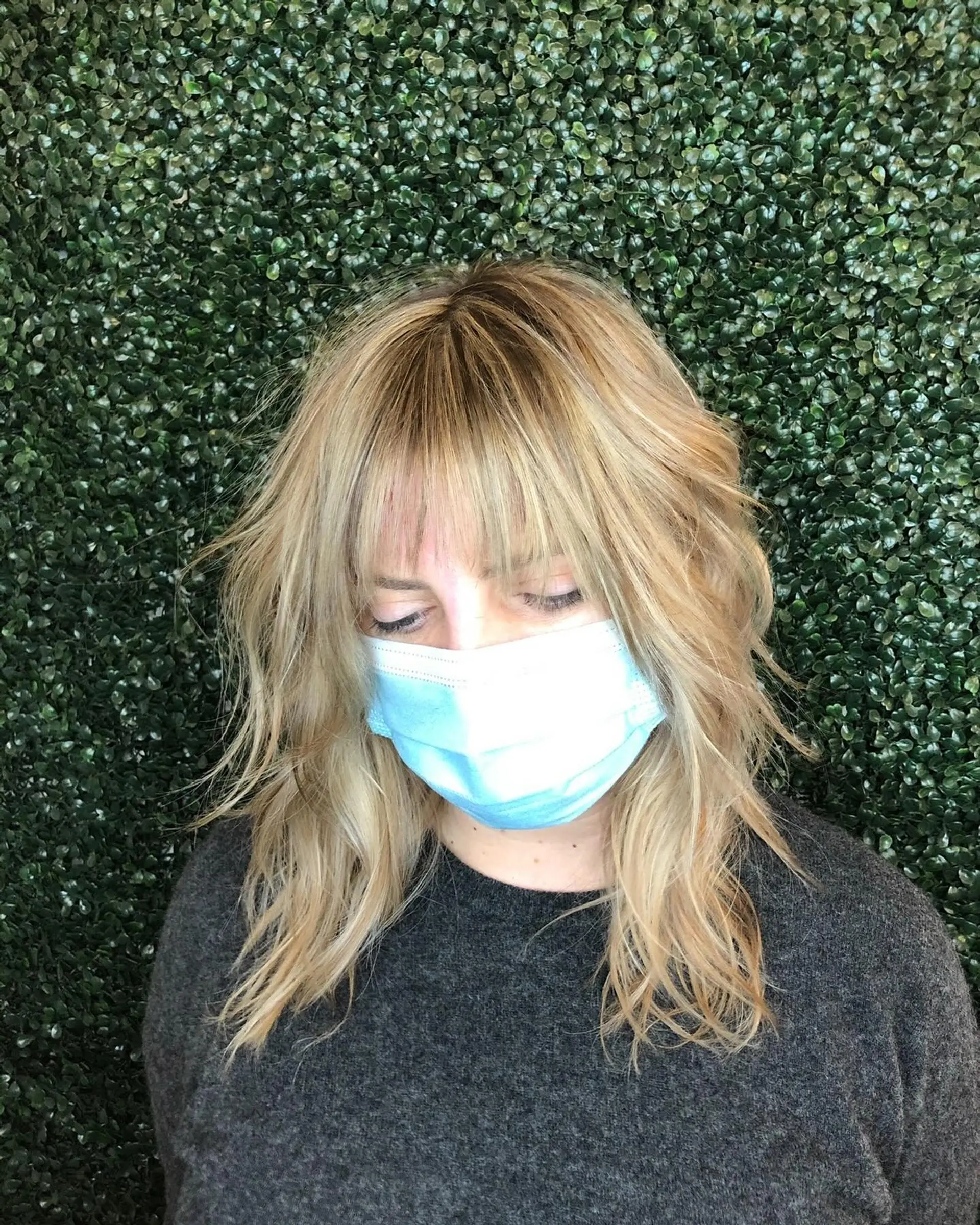 Medium-length textured blonde shag cut featuring feathered layers and full wispy fringe. 1