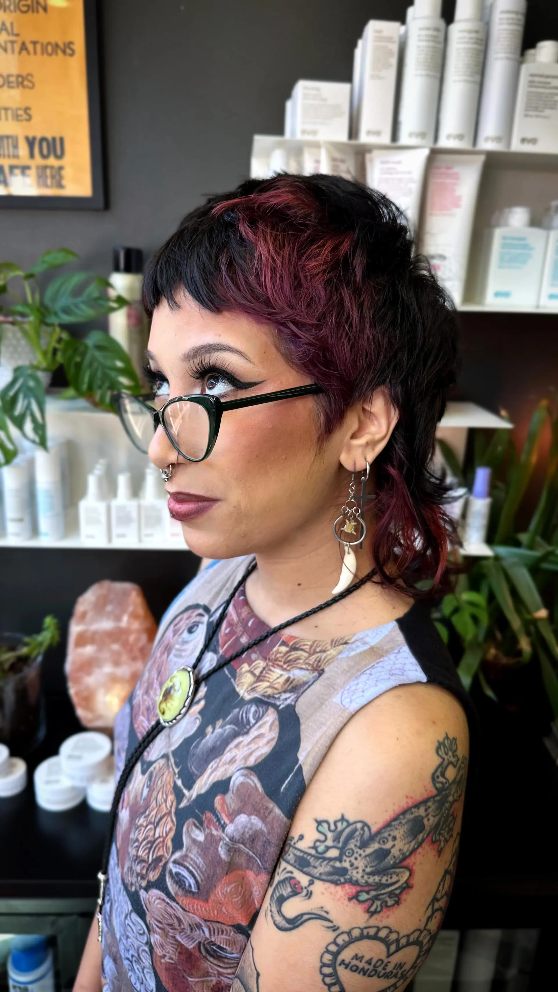 A textured mixie (pixie-mullet) featuring choppy micro bangs, piecey layers, and deep burgundy accents over a dark base. 1