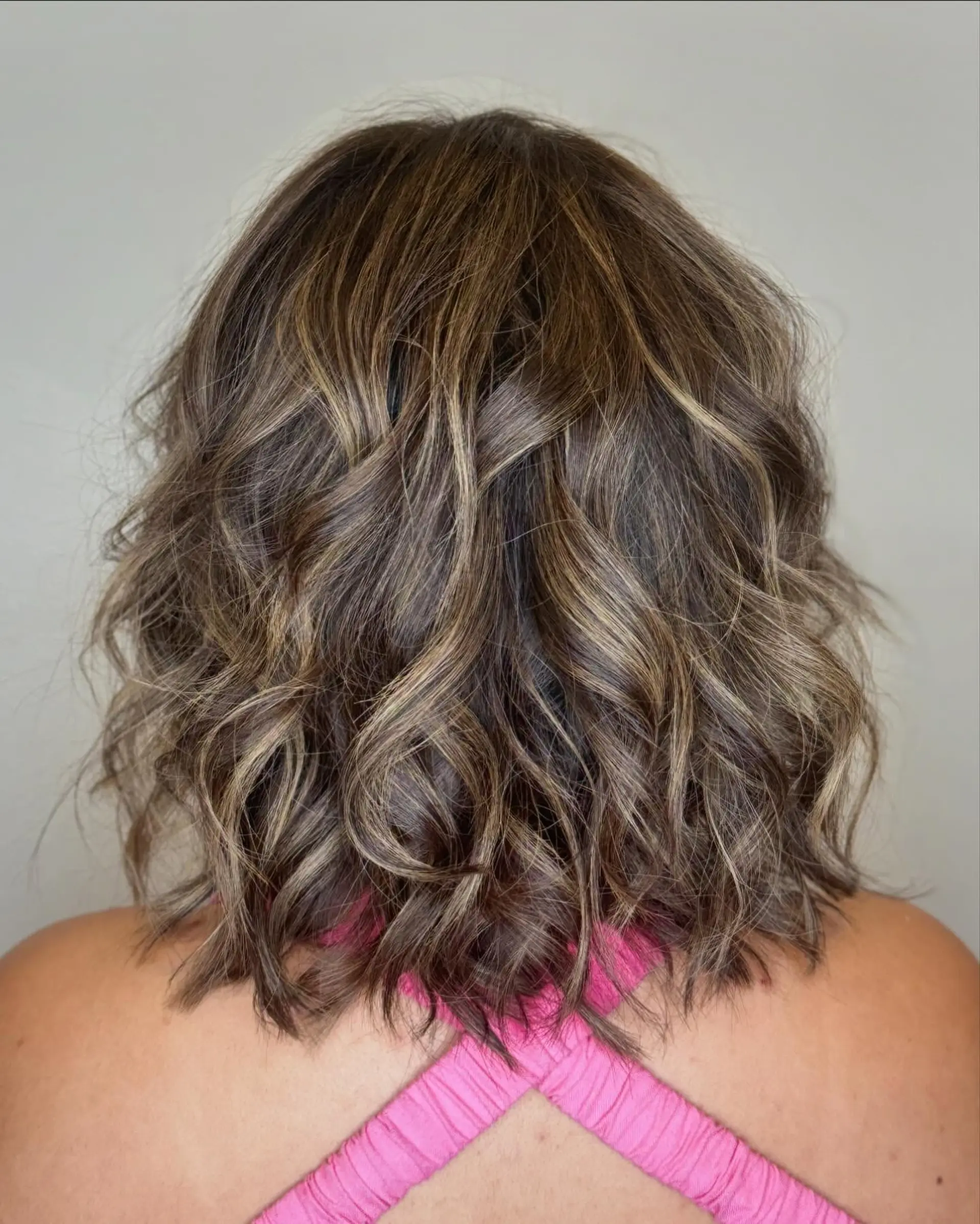 A textured shoulder-length bob styled with effortless, dimensional beach waves and blended balayage highlights. 1