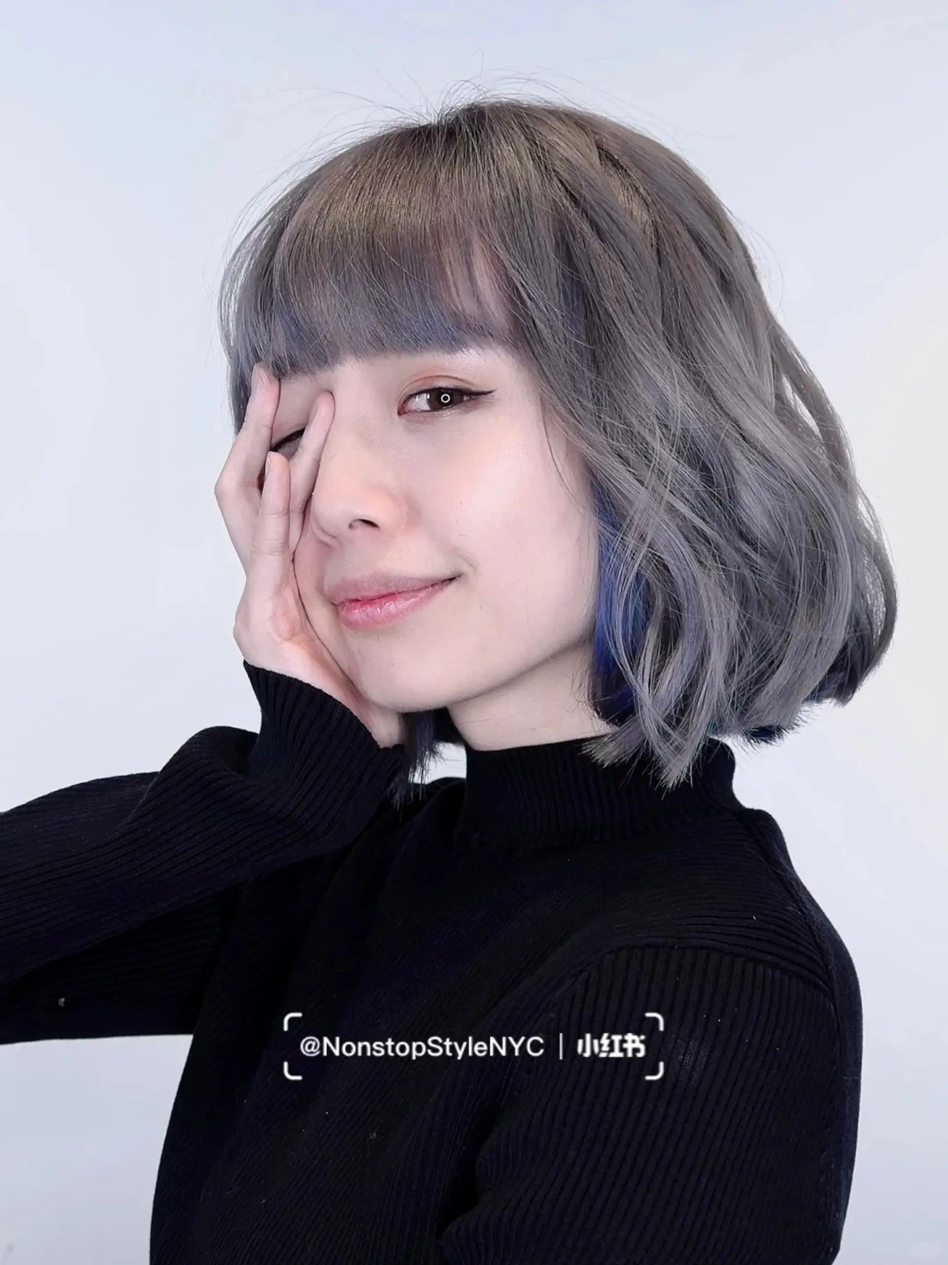 A modern bob haircut with loose, natural waves and straight-across bangs. The hair is shoulder-length, wavy, and colored in shades of silver and gray. Slightly layered ends add movement and volume.

 2