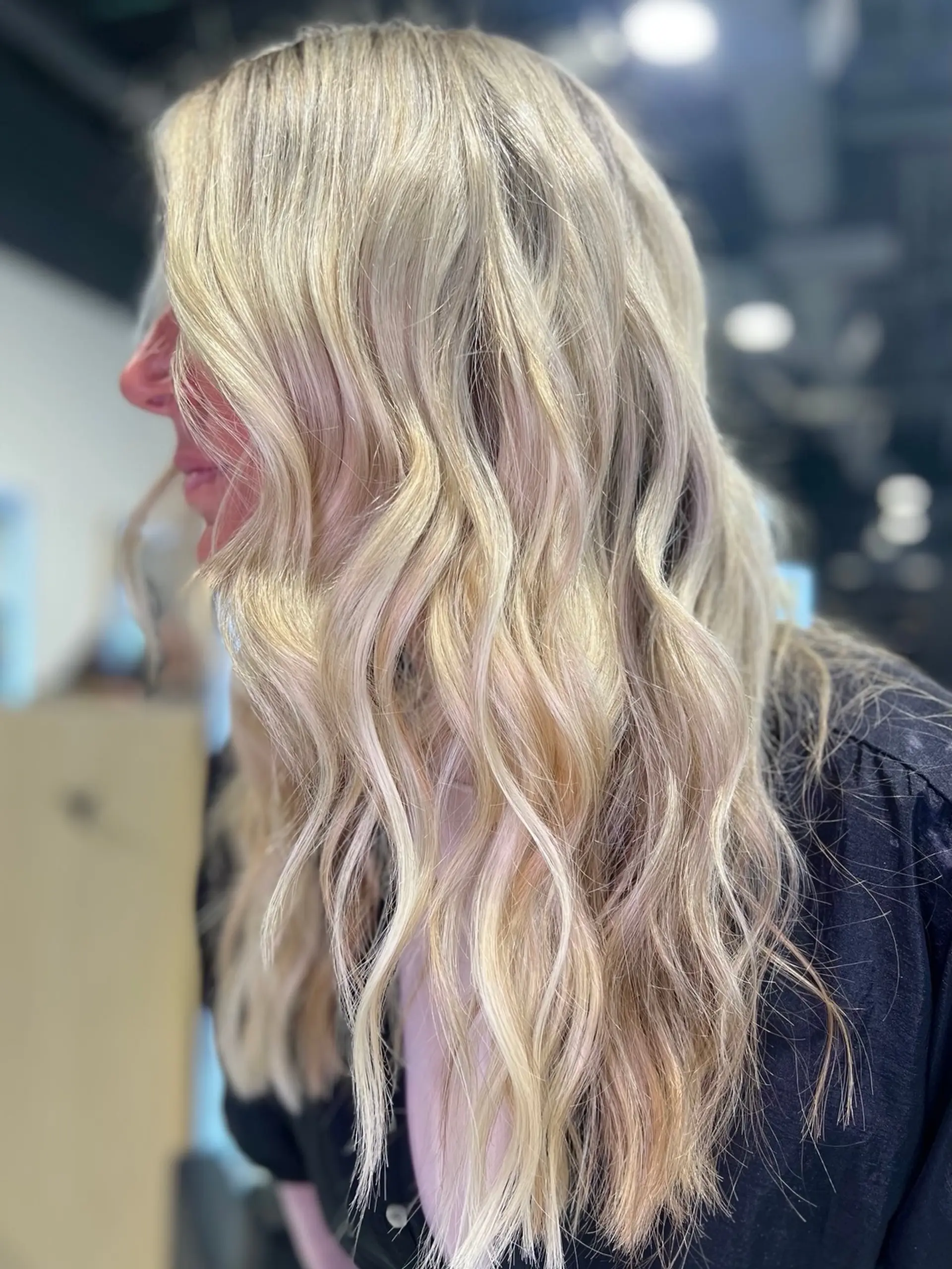 Long multi-tonal blonde hair styled into effortless, flowing beach waves. 1