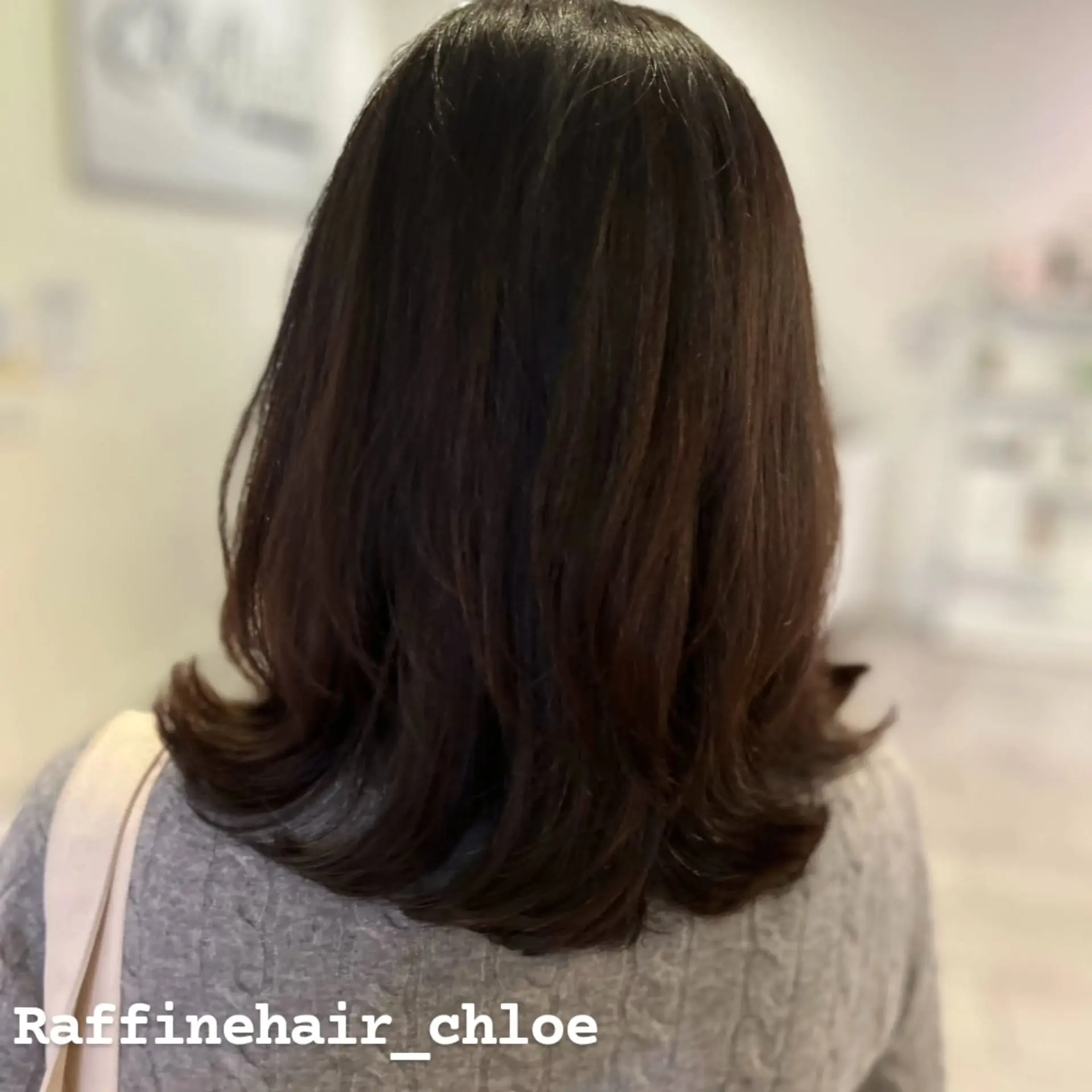 Medium-length dark brown hair featuring soft layers and smooth outward-flipping C-curls at the ends. 1