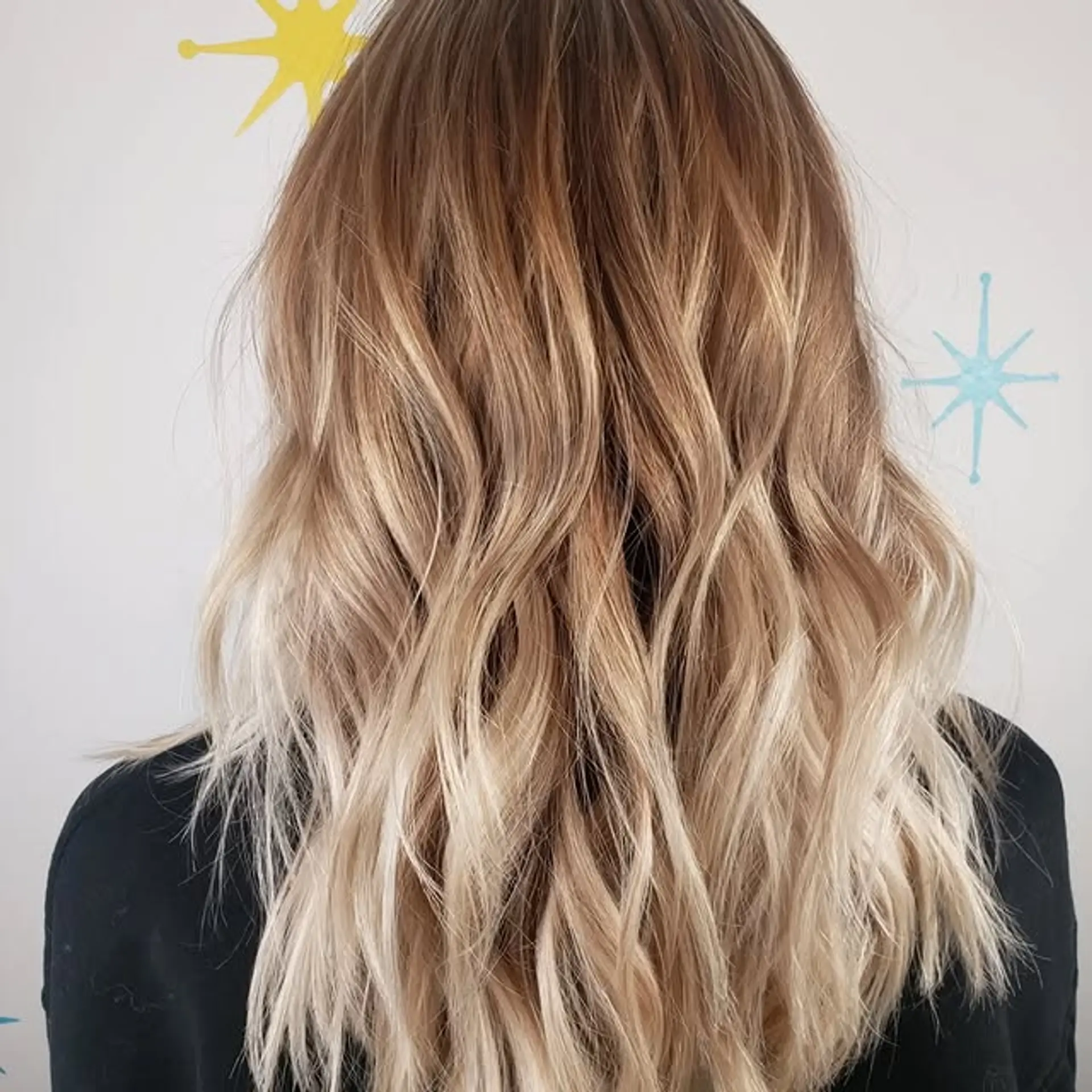 A wavy medium length hairstyle with an ombre color gradient. 1