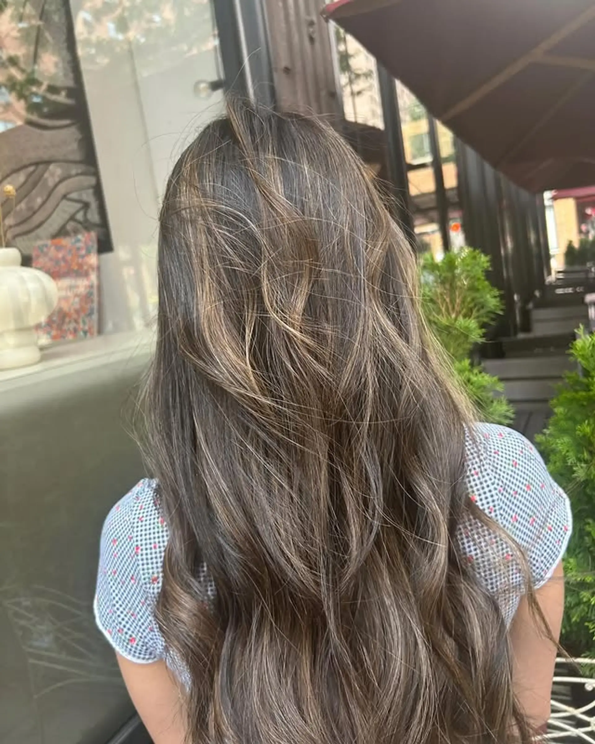 Long, wavy brunette hair with sun-kissed blonde highlights. 1