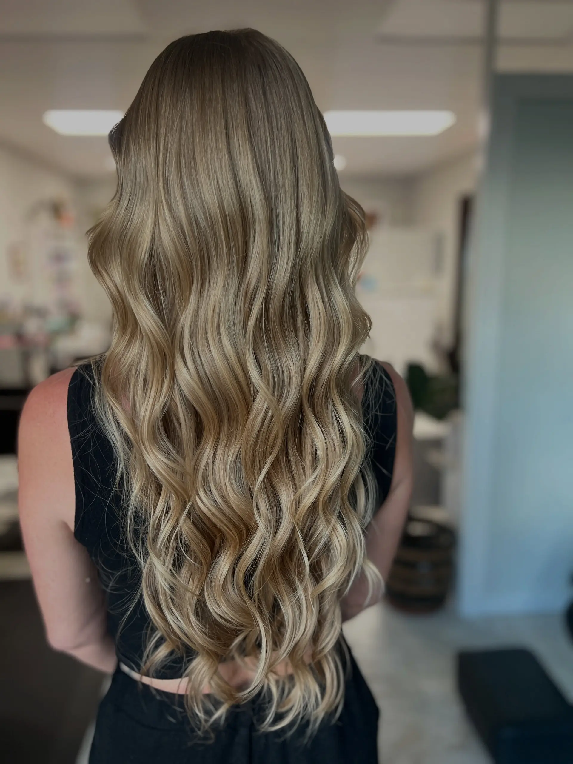 Extra-long natural blonde hair cut with flowing layers and styled in soft, cascading waves. 1