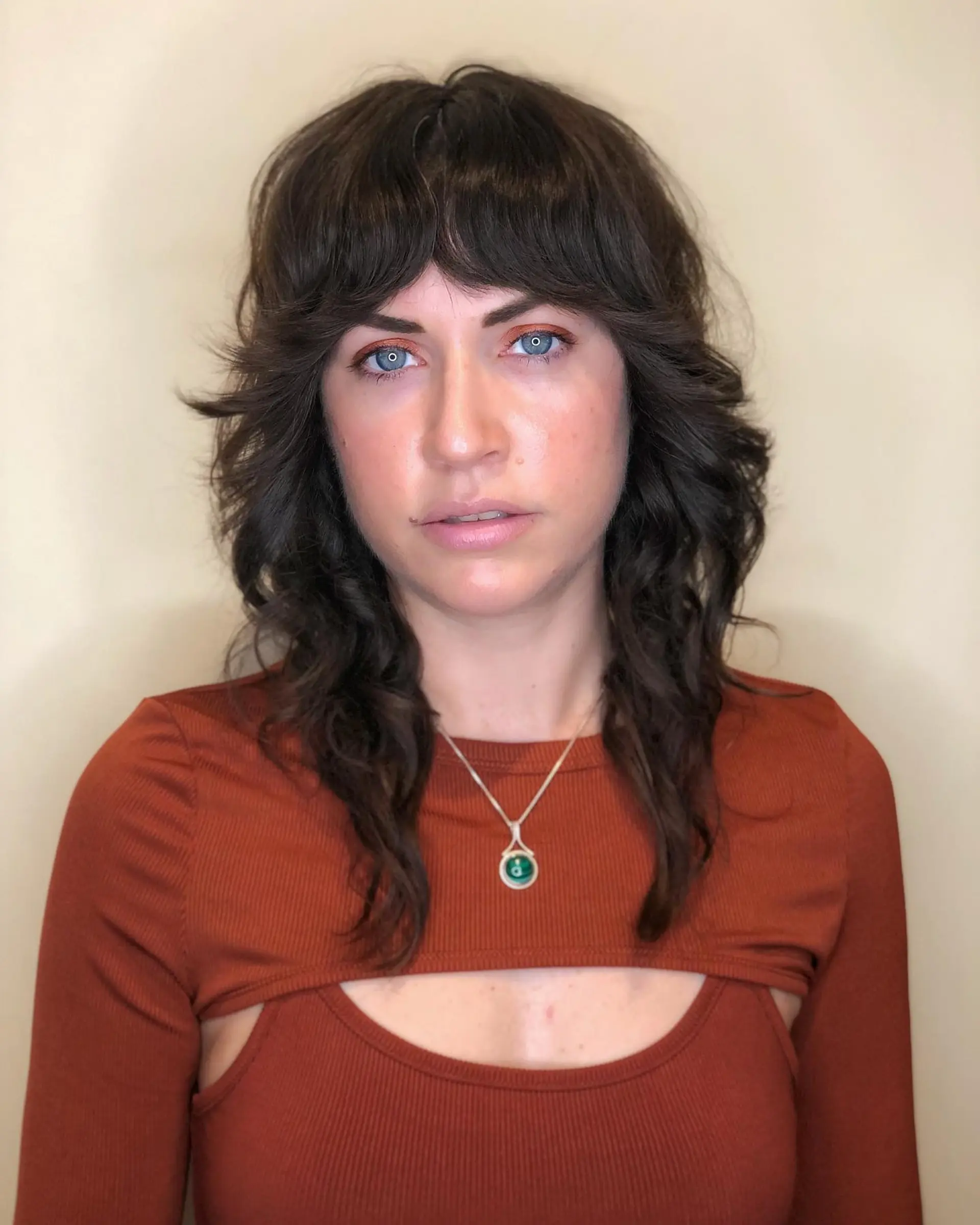 A medium-length shag haircut with layered texture and wispy bangs. 1