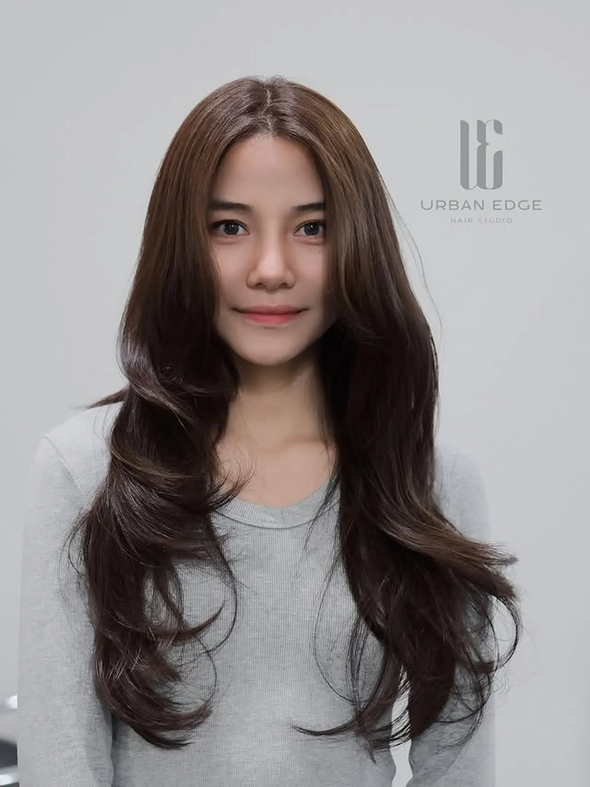 This hairstyle showcases a K-Wave digital perm for soft, voluminous, and bouncy waves throughout extra long hair. It's enhanced with butterfly layers that provide a flattering face-framing effect, creating a modern and elegant look. 1