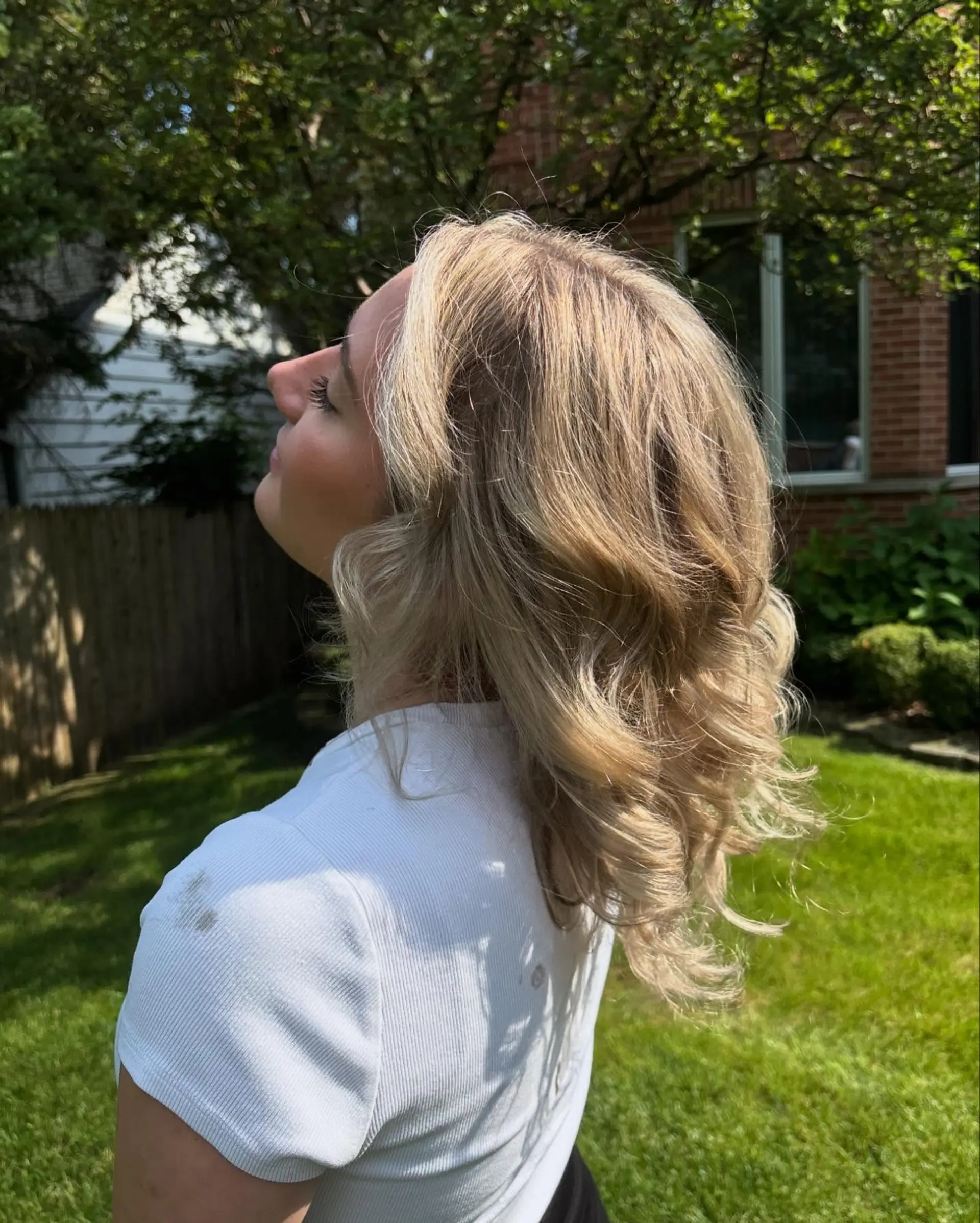 Shoulder-length dimensional blonde hair styled into soft, voluminous waves. 1