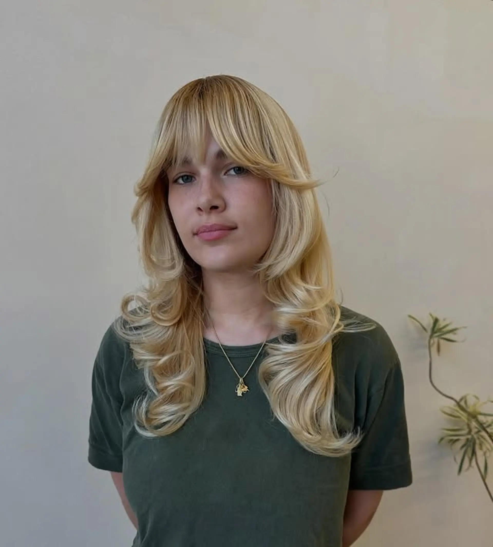 This medium-length hairstyle features face-framing layers and curtain bangs. 1