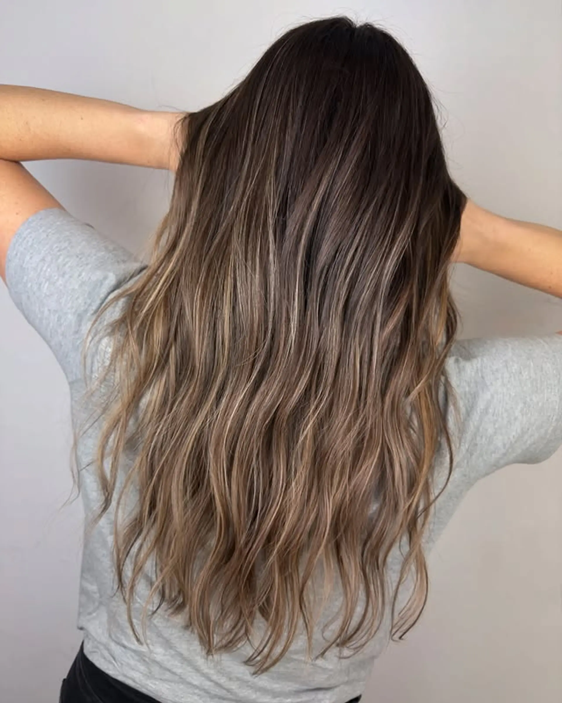 A long, wavy hairstyle with caramel and blonde balayage highlights. 1