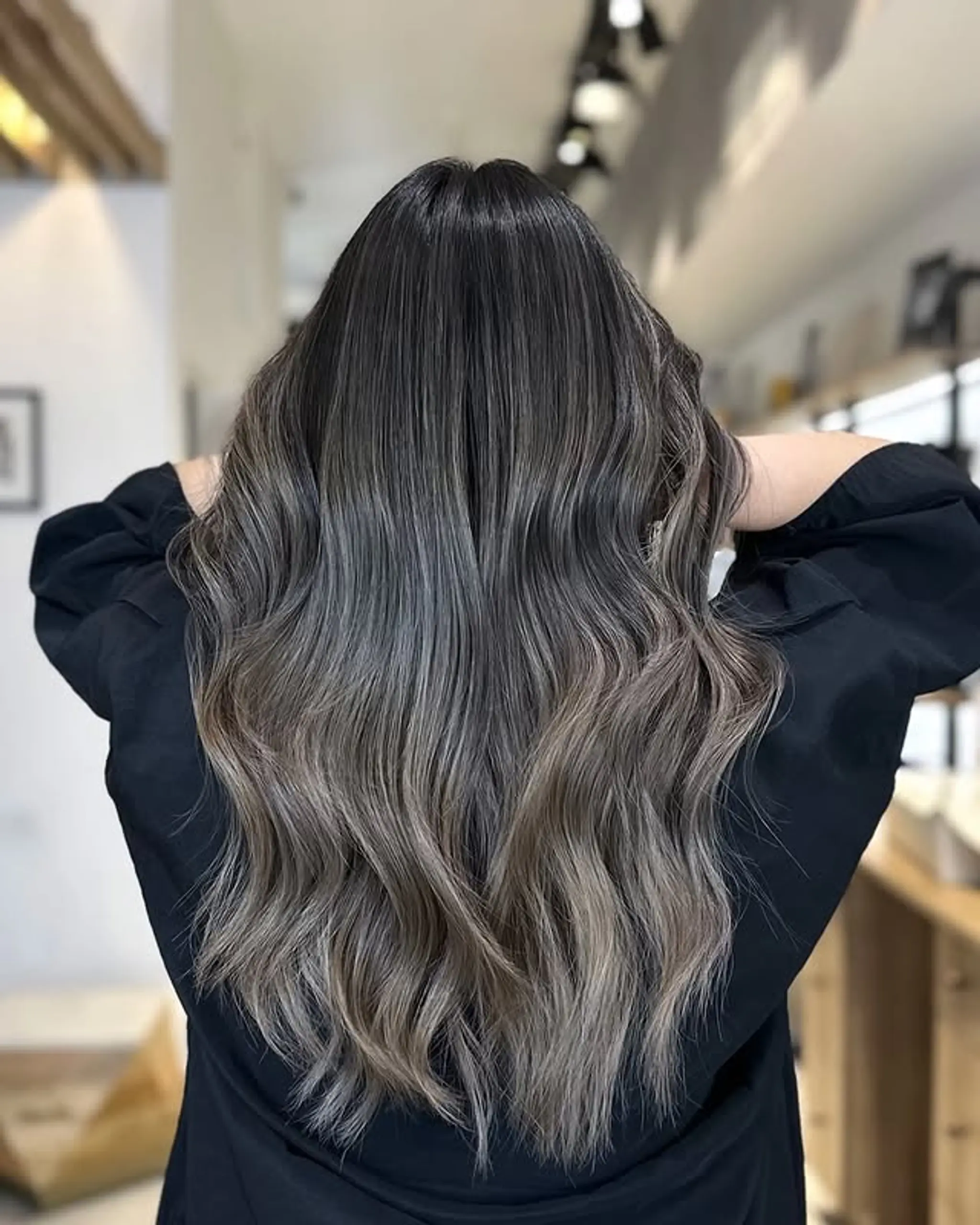 Long wavy hair with a subtle ash blonde balayage.