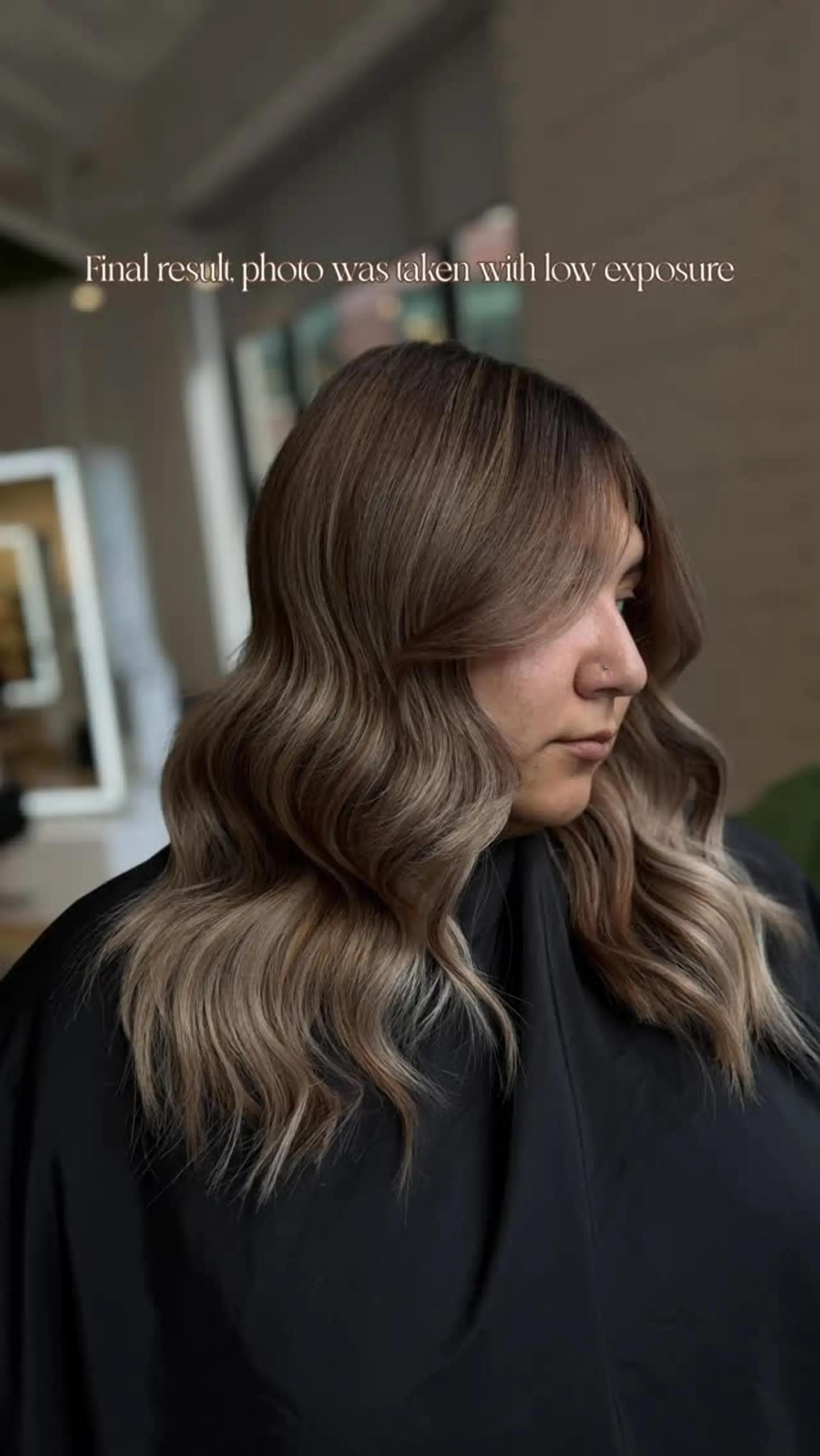A seamless bronde balayage with rich brown roots blending into soft blonde ribbons, styled in glossy loose waves with face-framing curtain bangs. 1
