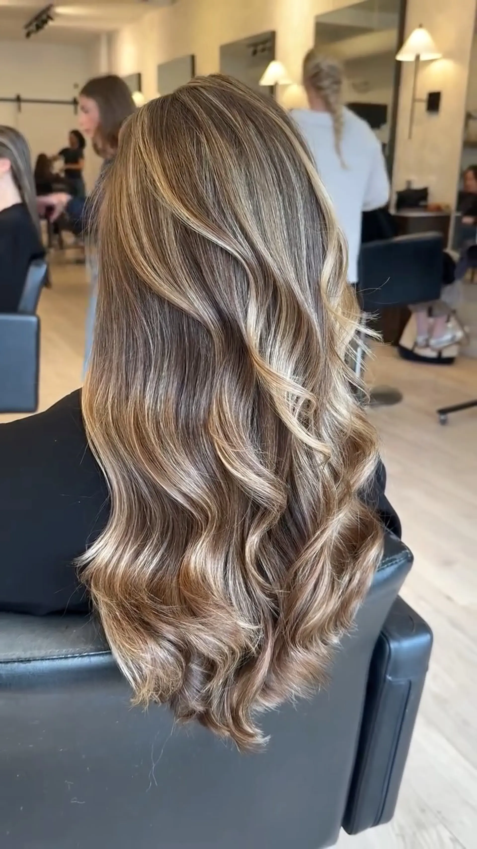 Long dimensional blonde highlights blended seamlessly over a light brown base and styled into soft, cascading waves. 1