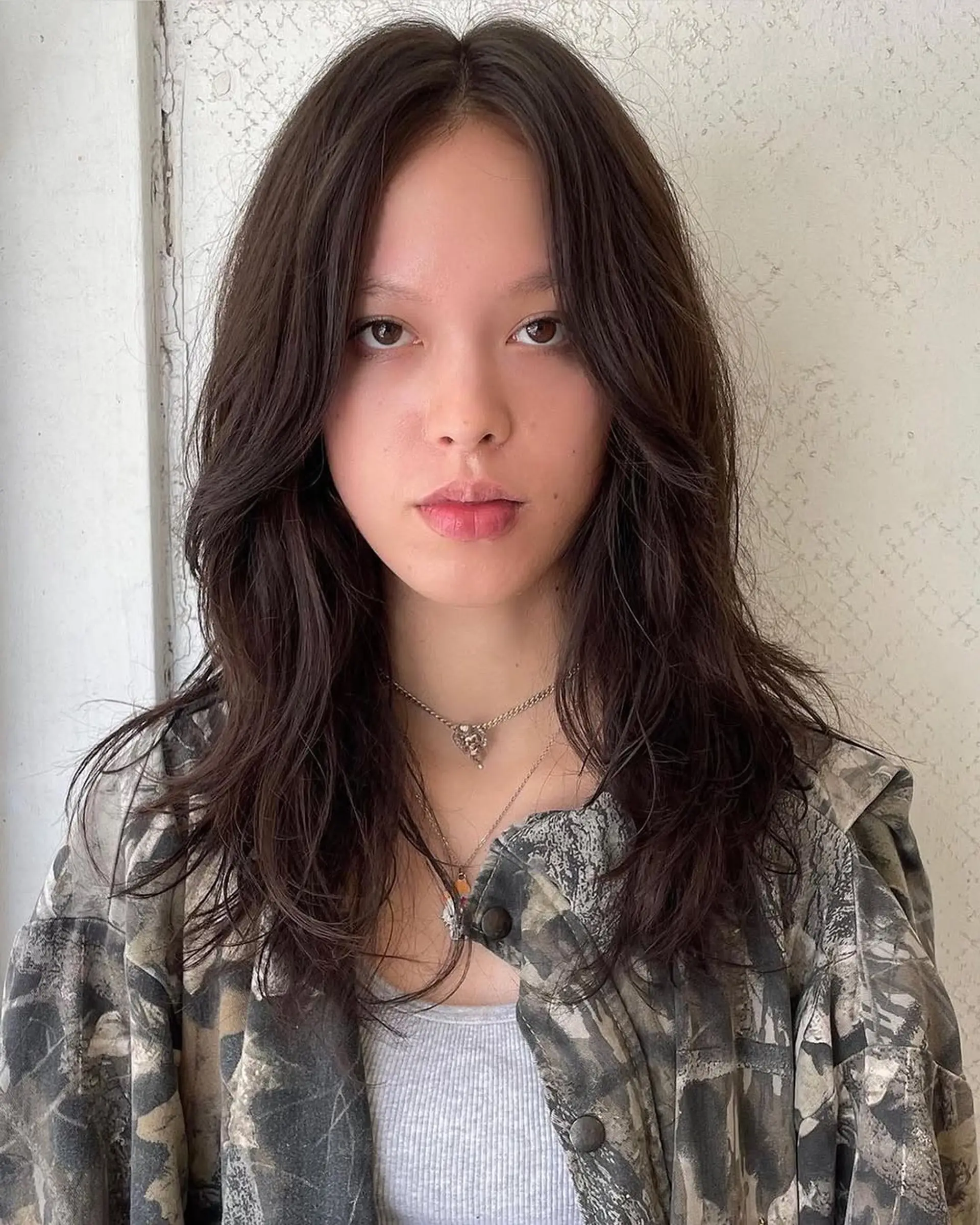 Medium-length, wavy dark brown hair with soft waves and face-framing layers. 2