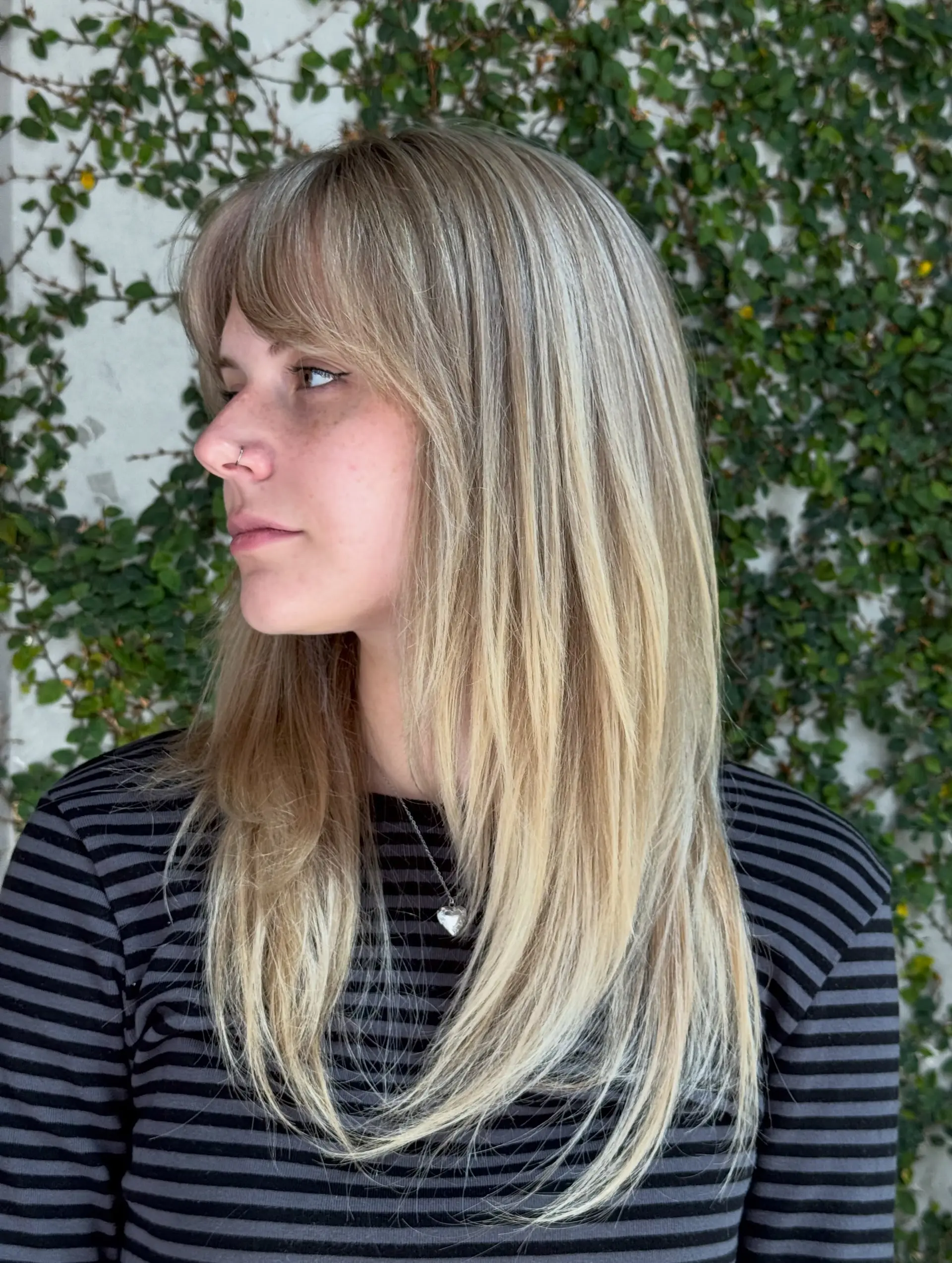 Long straight blonde hair styled with soft full bangs and face-framing layers. 1