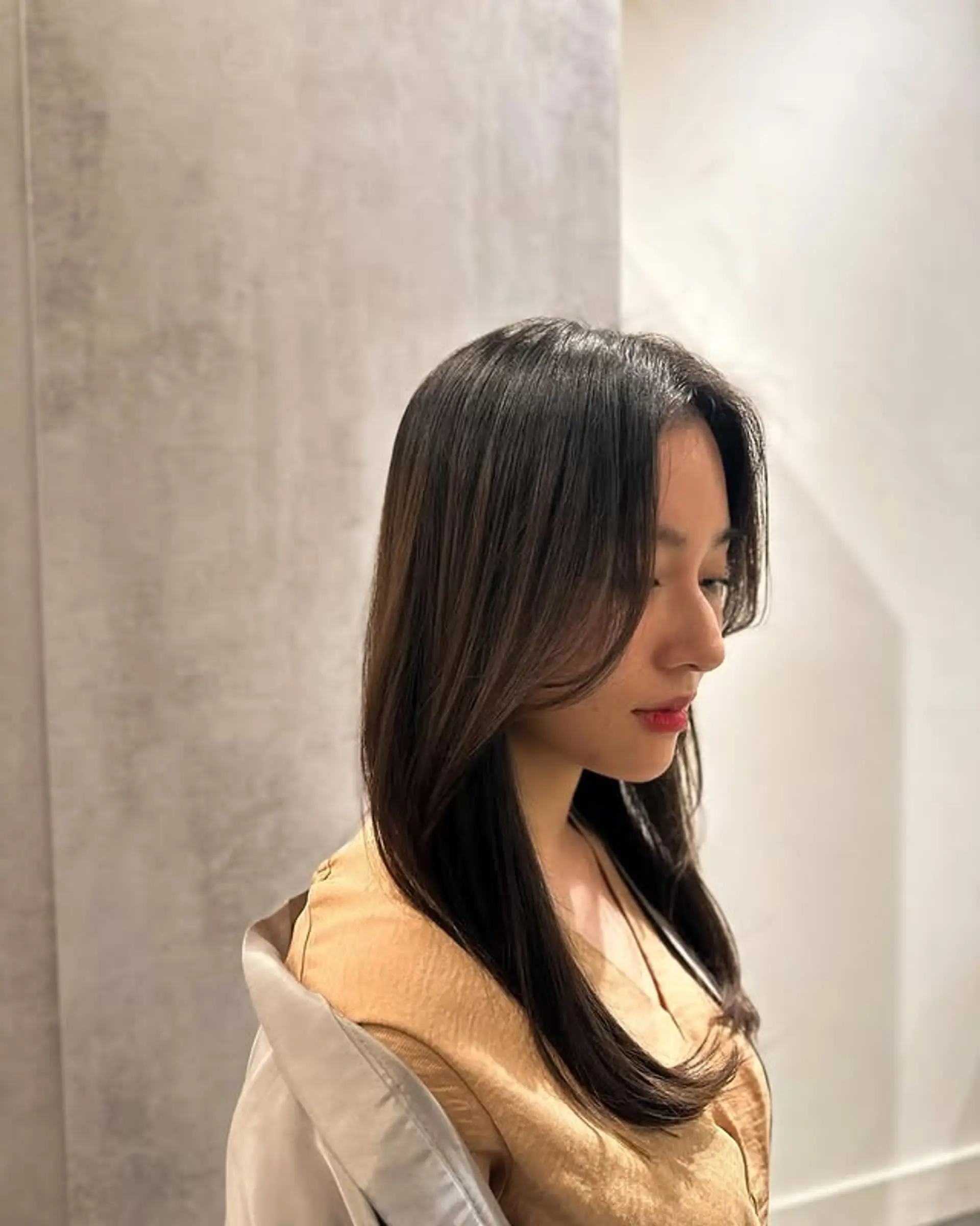 A layered long haircut featuring face-framing layers and curtain bangs. 1