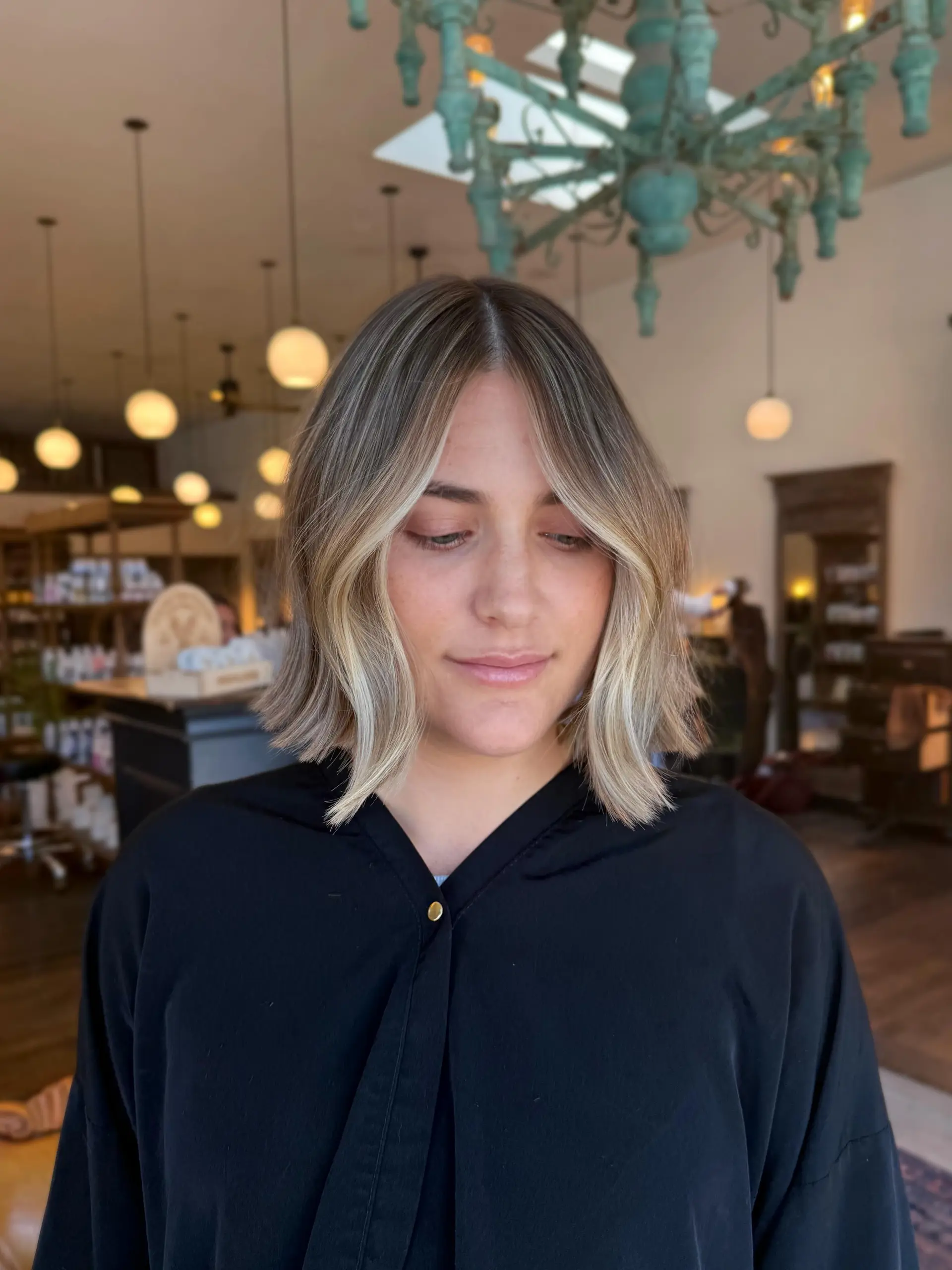 A stylish chin-length textured bob with a center part and bright blonde face-framing highlights. 1