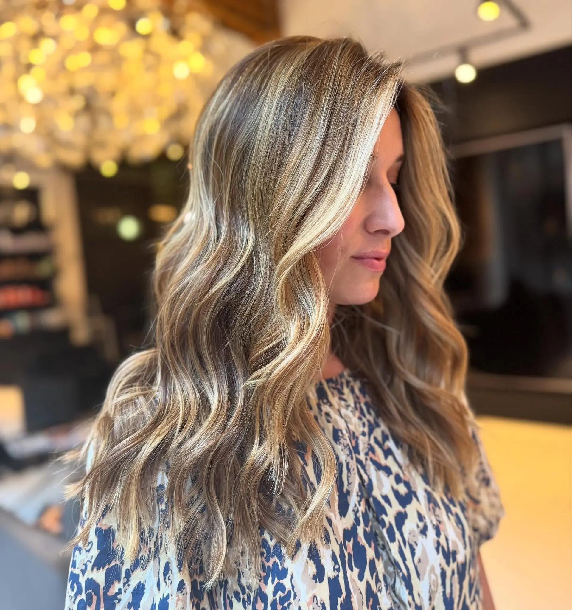 Long hair featuring dimensional blonde highlights styled into loose, flowing waves. 1