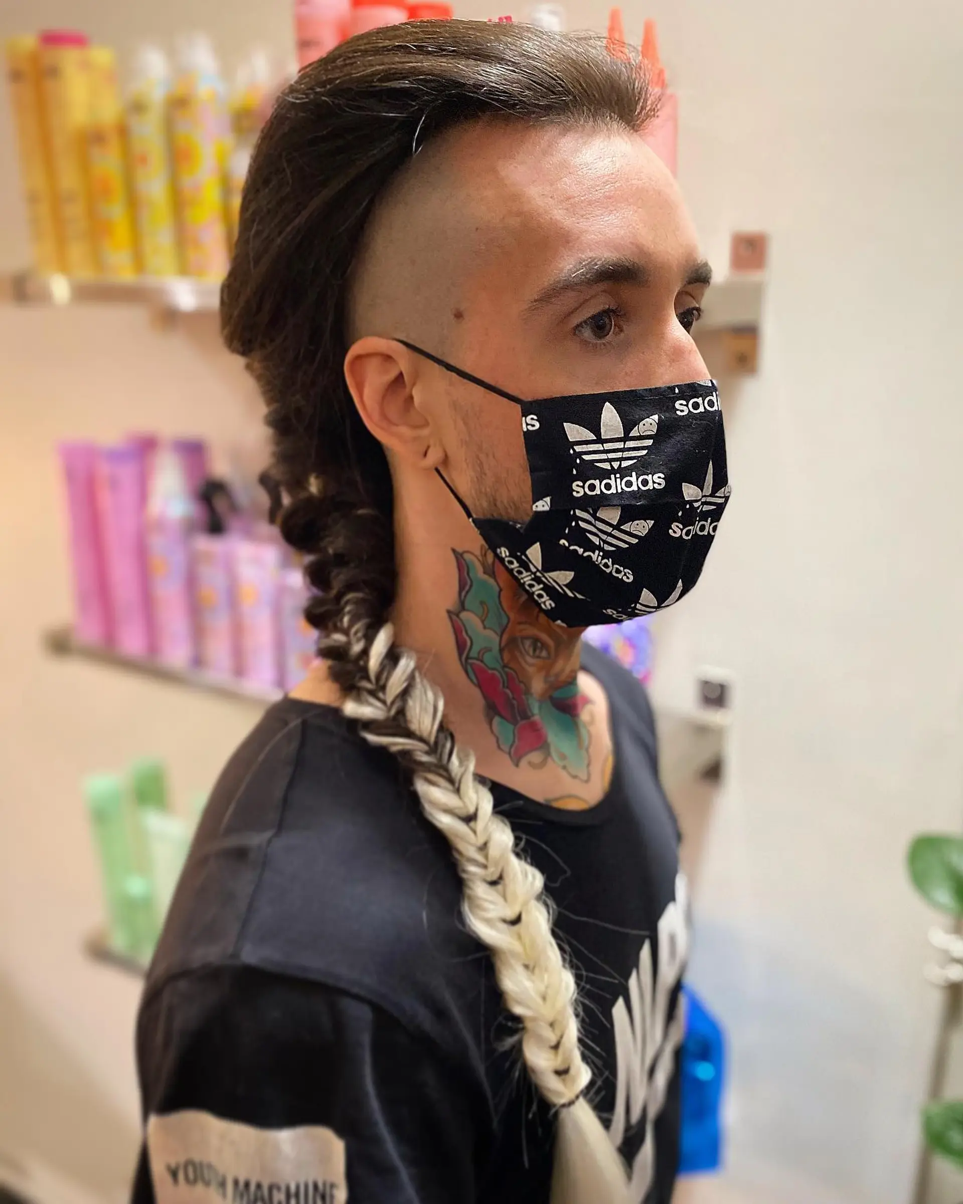 A dramatic high undercut with clean shaved sides, featuring long hair swept back into an intricate two-tone fishtail braid. 1