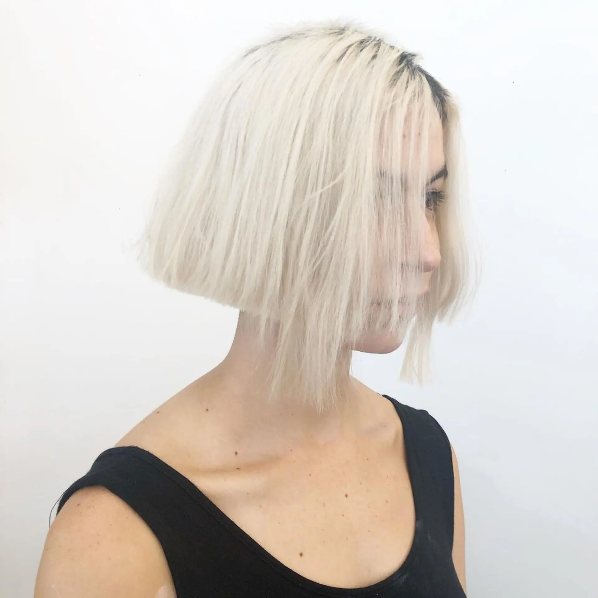 A sleek and blunt bob cut in platinum blonde, with unique longer bangs. 1