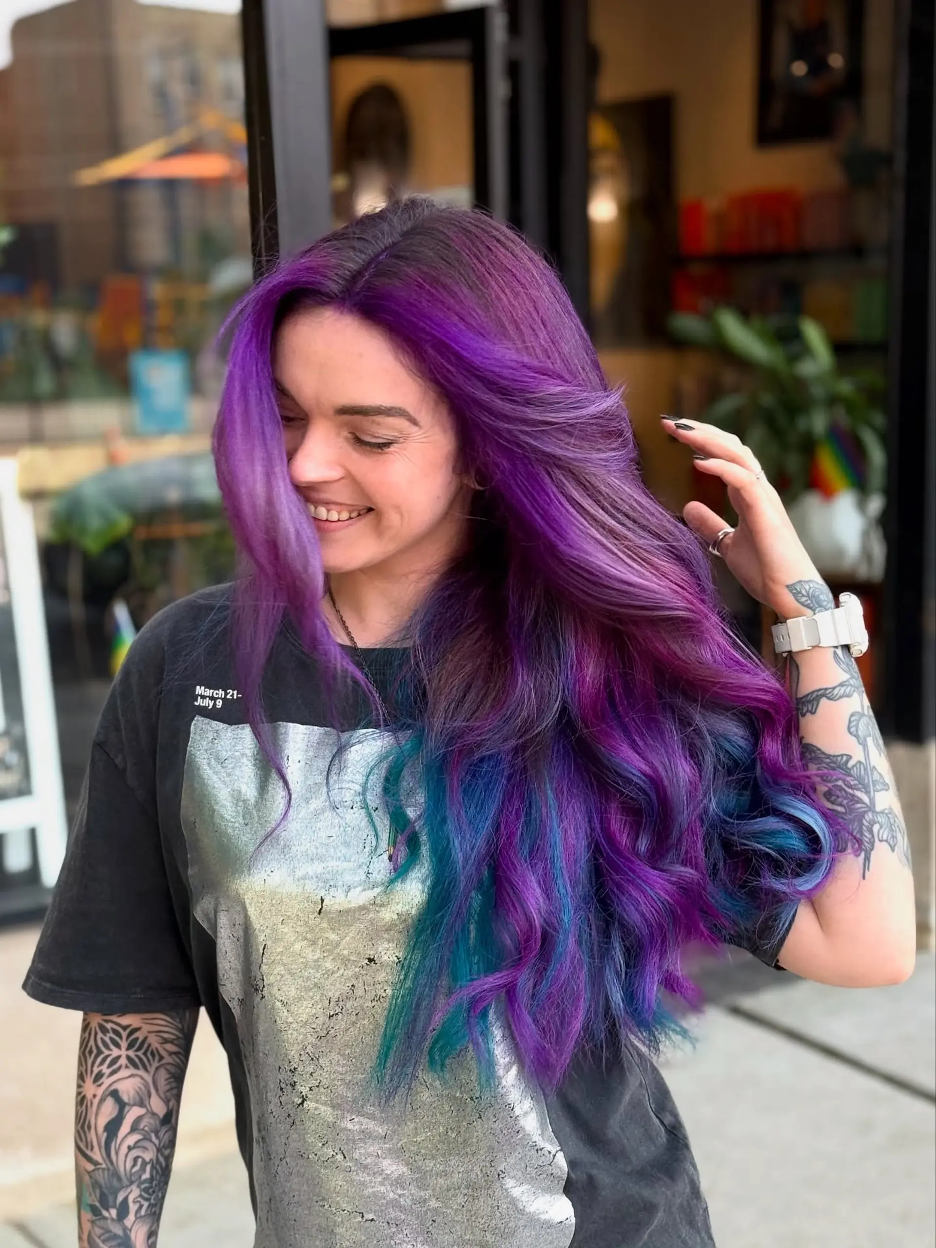 Long voluminous hair colored in vibrant shades of rich purple blending into brilliant teal and blue undertones, styled in loose cascading waves. 1