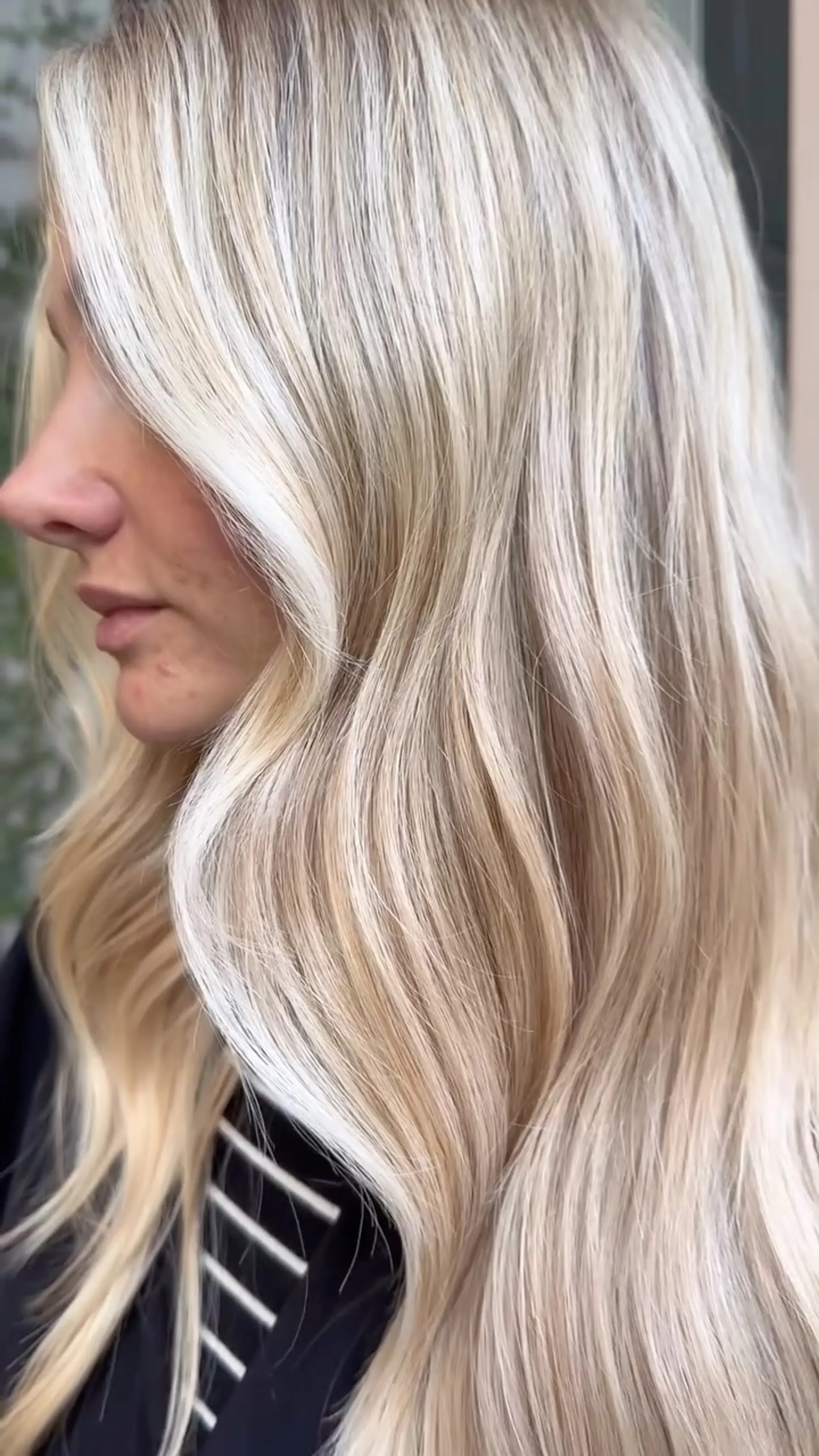 Long dimensional blonde hair styled in soft, elegant waves cascading over the shoulder. 1