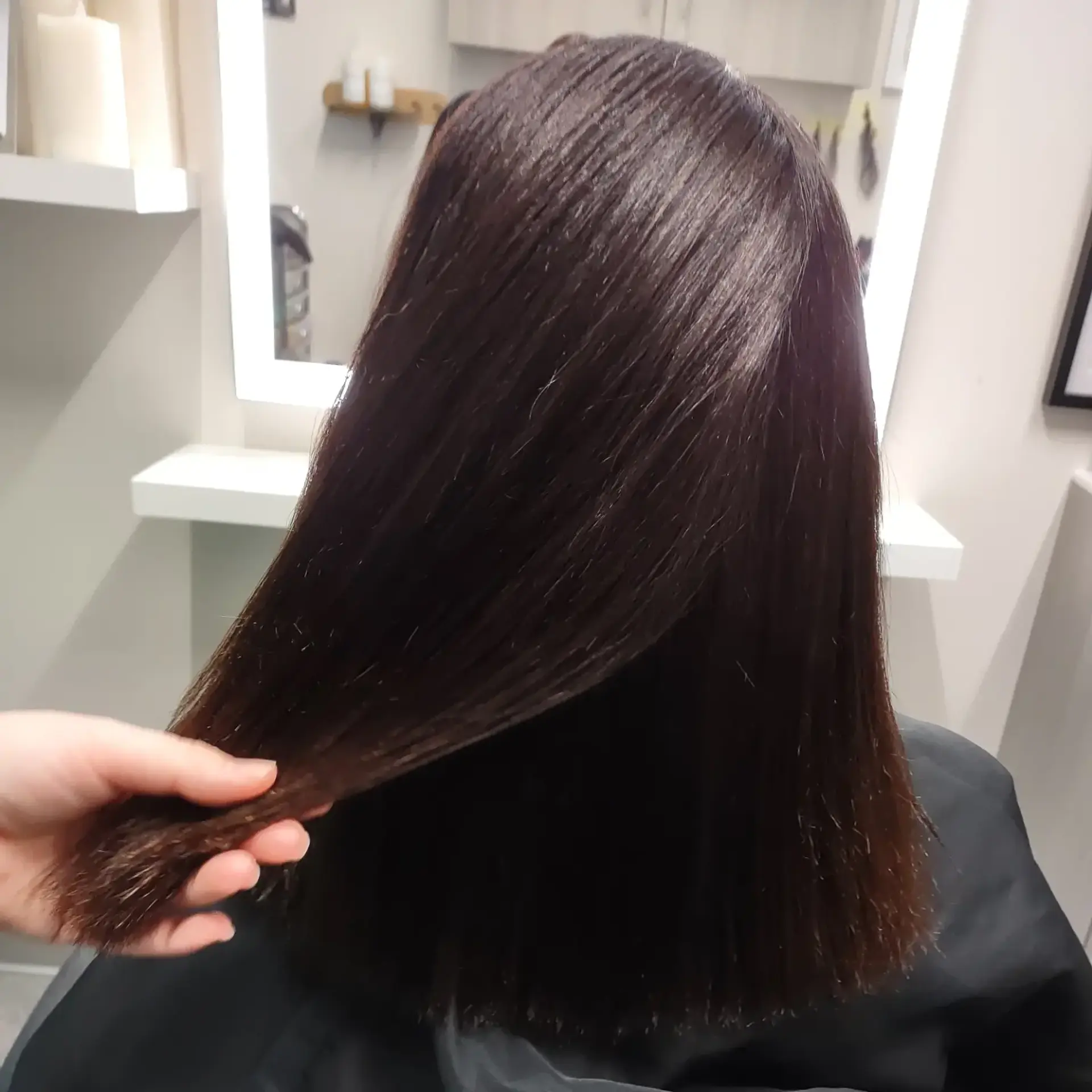 Glossy, pin-straight medium-length dark brown hair featuring a clean blunt cut. 1