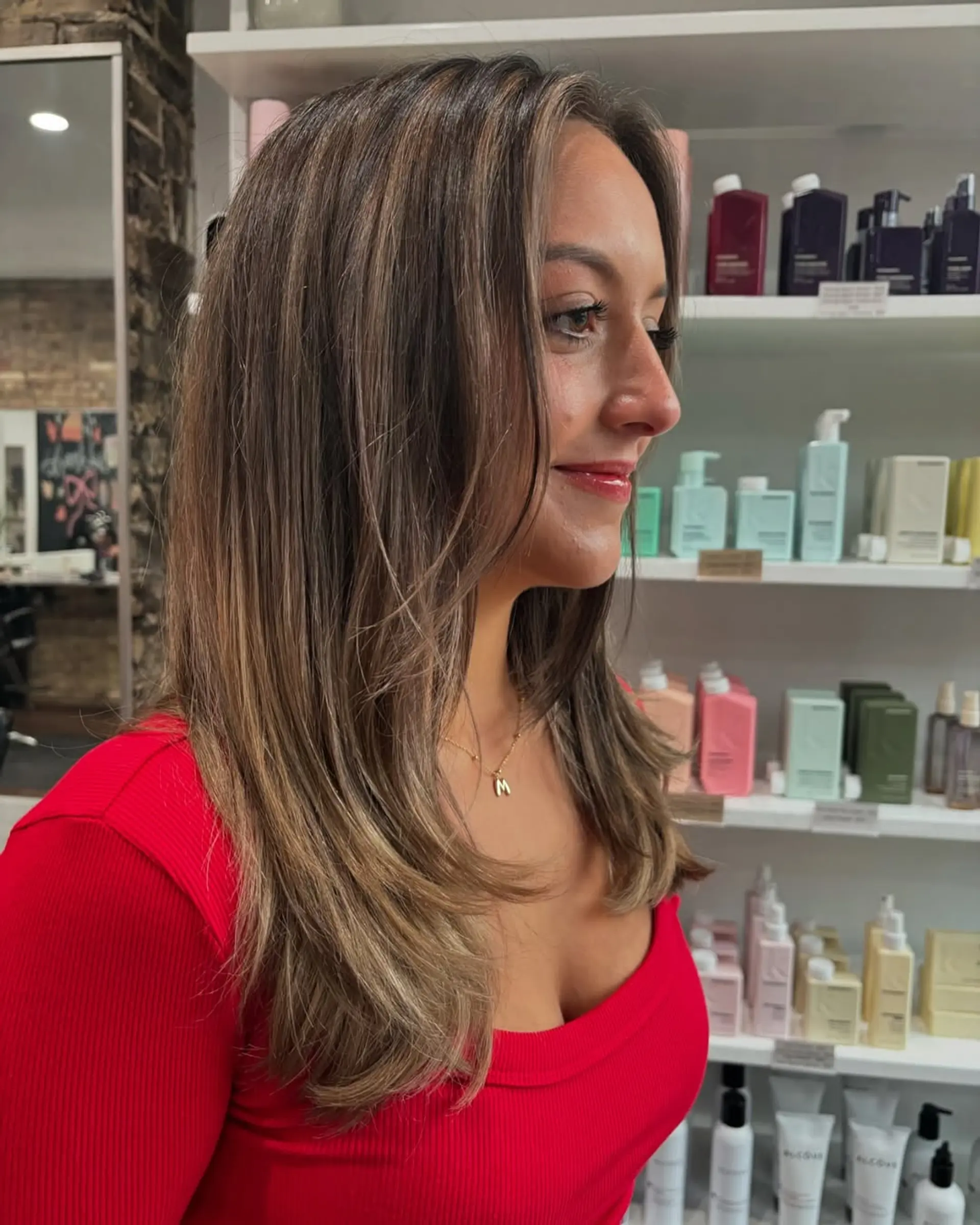A chic medium-length haircut with soft face-framing layers and subtle longer layers throughout, enhanced by a dimensional caramel and light brown balayage that adds depth and a sun-kissed glow. 3