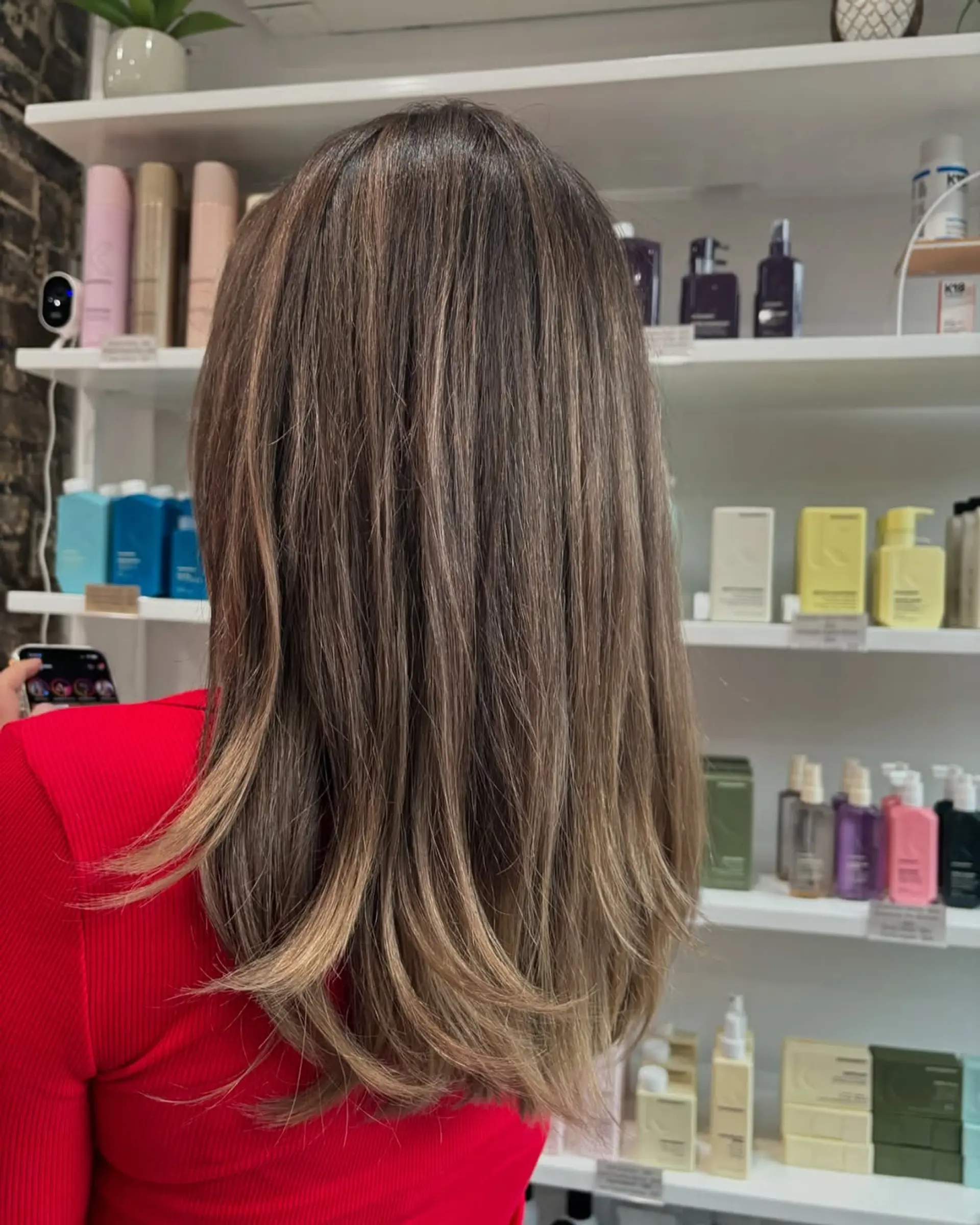 A chic medium-length haircut with soft face-framing layers and subtle longer layers throughout, enhanced by a dimensional caramel and light brown balayage that adds depth and a sun-kissed glow. 2