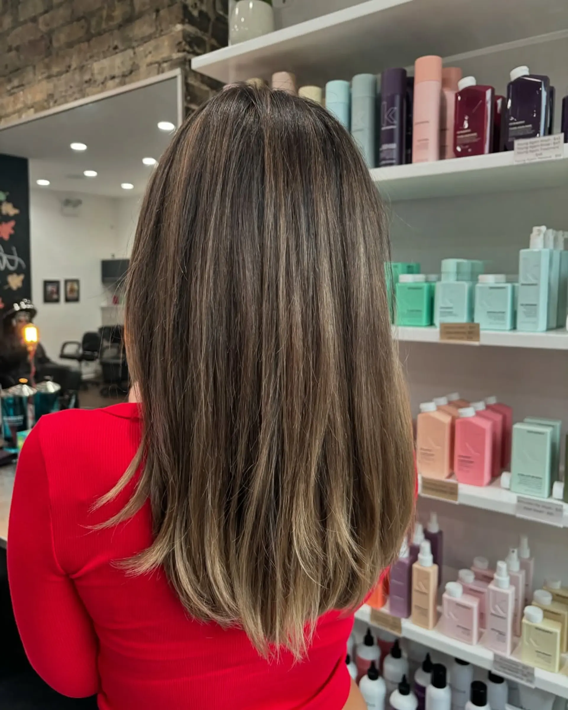 A chic medium-length haircut with soft face-framing layers and subtle longer layers throughout, enhanced by a dimensional caramel and light brown balayage that adds depth and a sun-kissed glow. 1