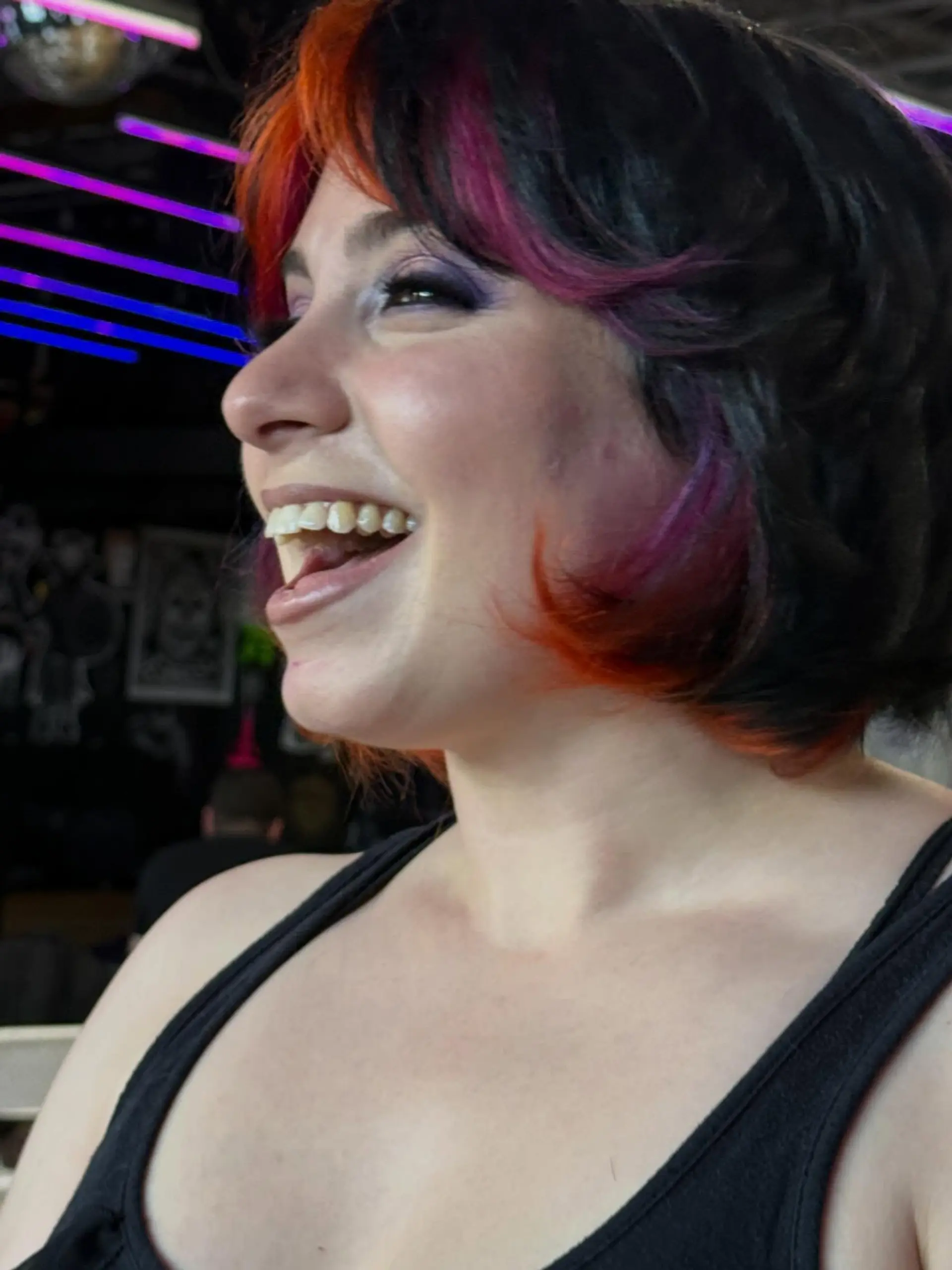 A textured, short shaggy bob with curtain fringe featuring a dark base accented with vivid orange and magenta color blocks. 1