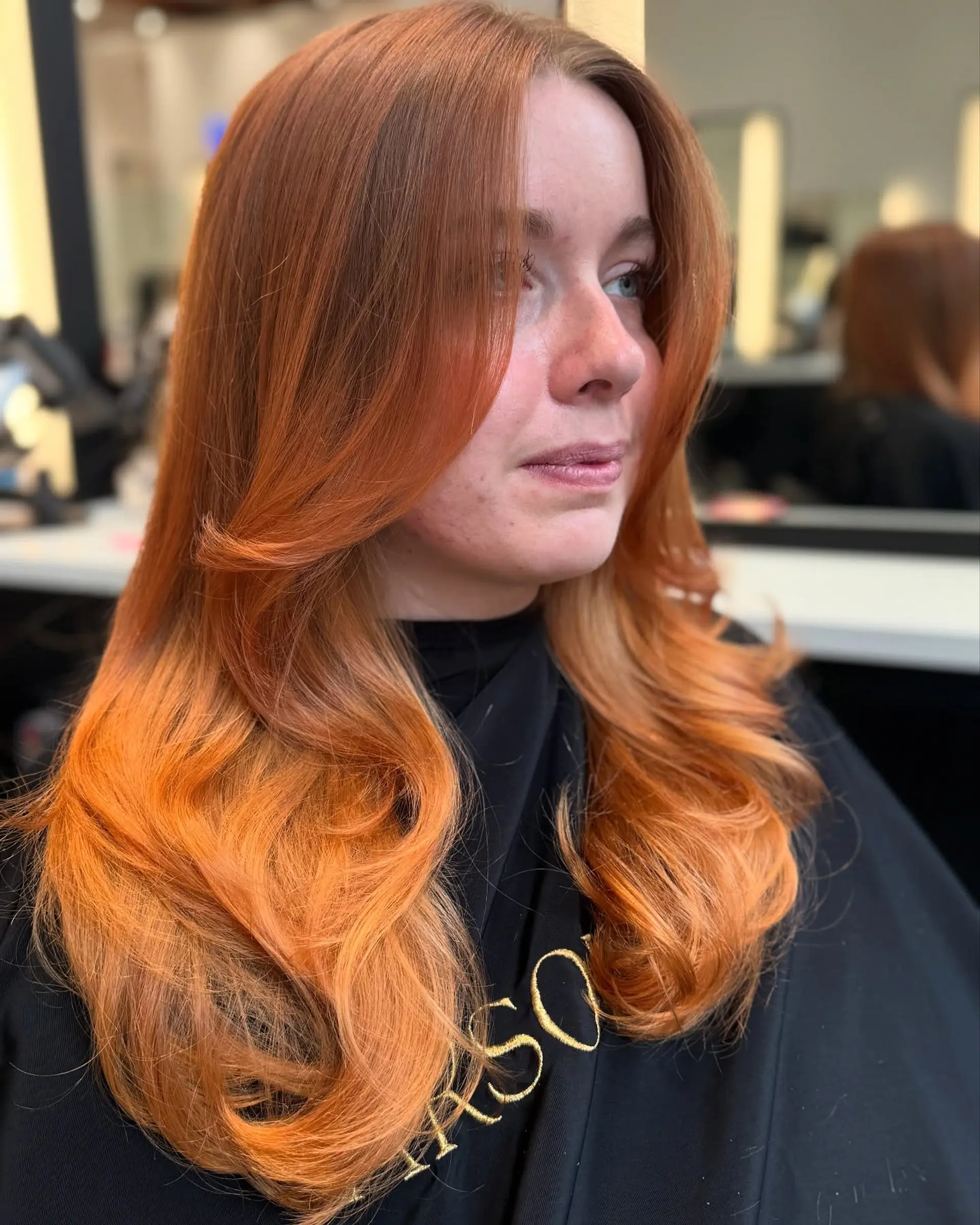 A medium-length, layered haircut with face-framing layers and a smooth blowout finish. 3