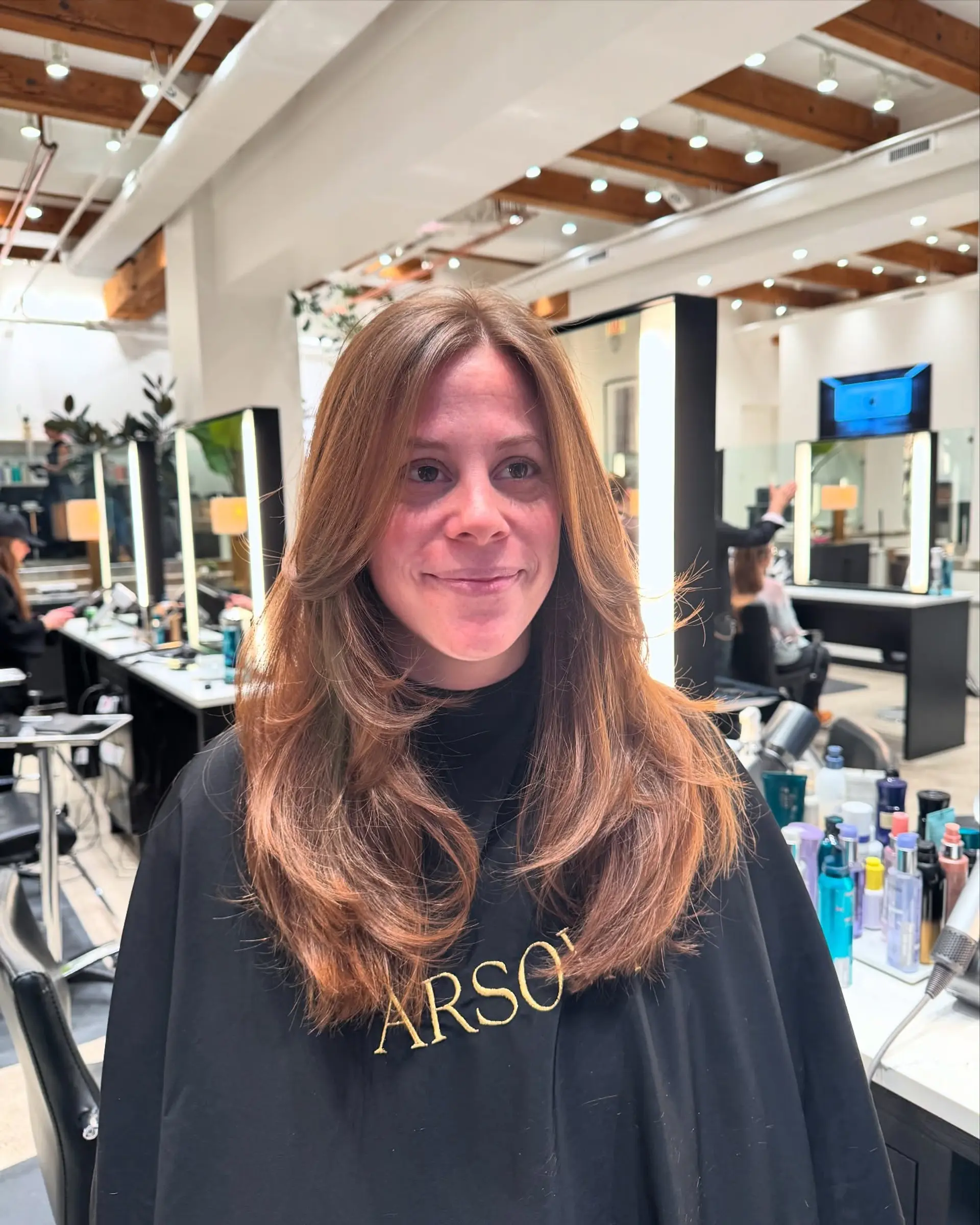 A medium-length, layered haircut with face-framing layers and a smooth blowout finish. 5