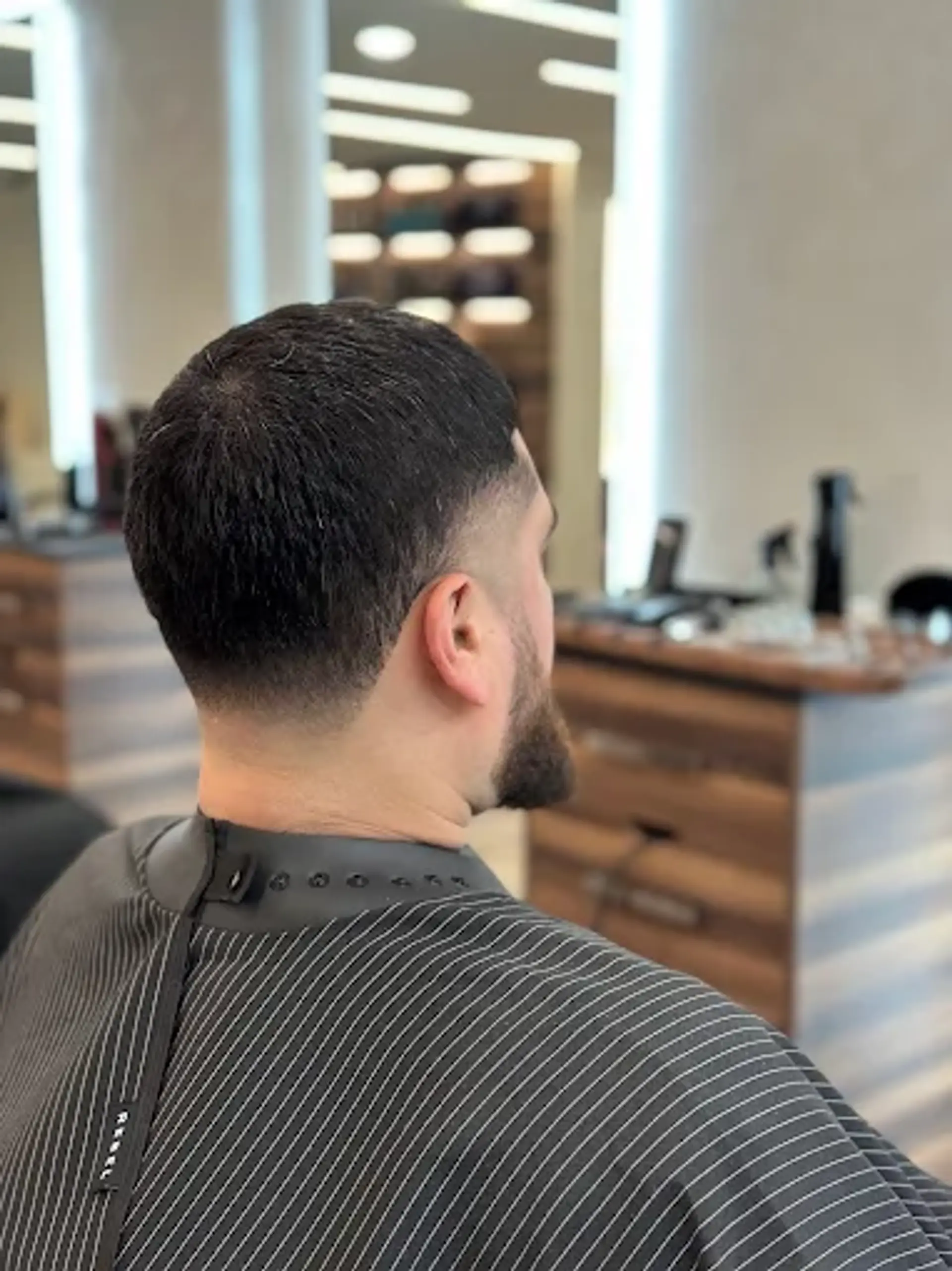 A classic men's low taper fade with short, textured hair on top, seamlessly faded on the sides and back for a clean and contemporary finish. 1