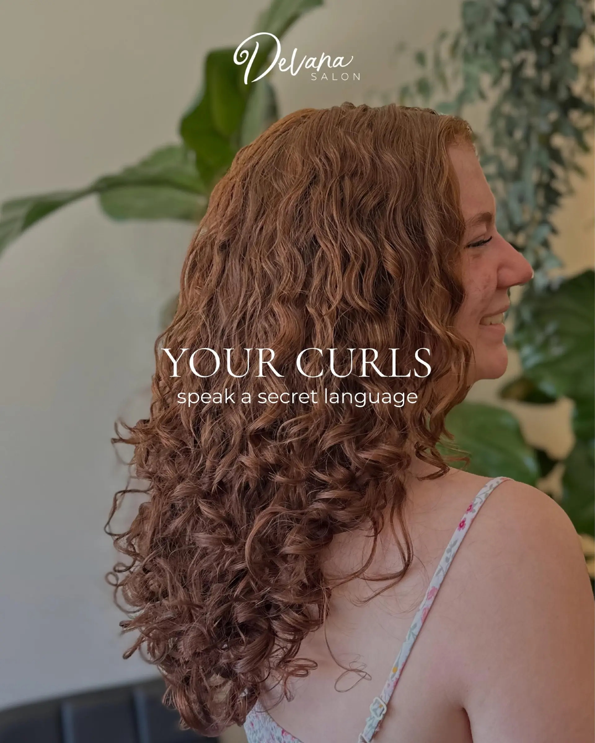 Long, defined copper-auburn curls cut in soft layers to enhance volume and natural ringlet formation. 1
